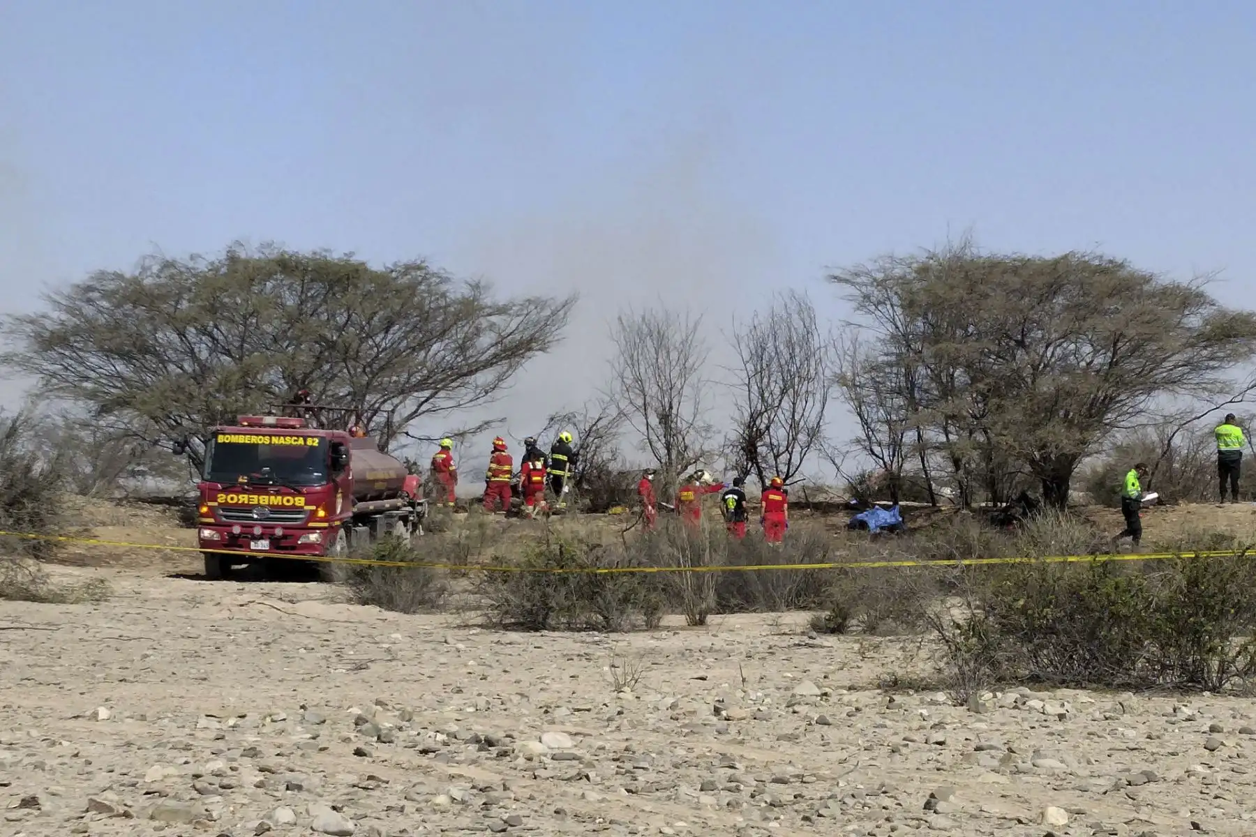 Integrantes de los Bomberos de Nazca operan en la zona donde una avioneta que sobrevolaba sobre las Líneas de Nazca se estrelló y dejó trece personas fallecidas, entre ellos 11 turistas, este sábado, en la municipalidad provincial de Nazca (Perú). EFE/Victor Quilca