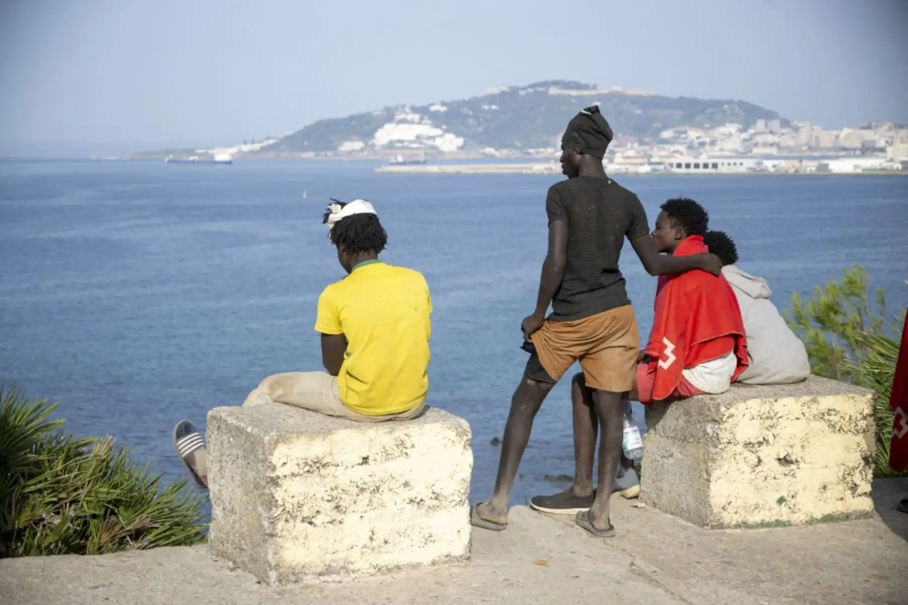 Migrantes se congregan en playas y diversos puntos de la ciudad mientras las autoridades españolas instalan una barrera marítima flotante frente a la costa de Ceuta para impedir los cruces irregulares hacia el enclave español en el norte de África, el 1 de agosto de 2026. Foto: AFP