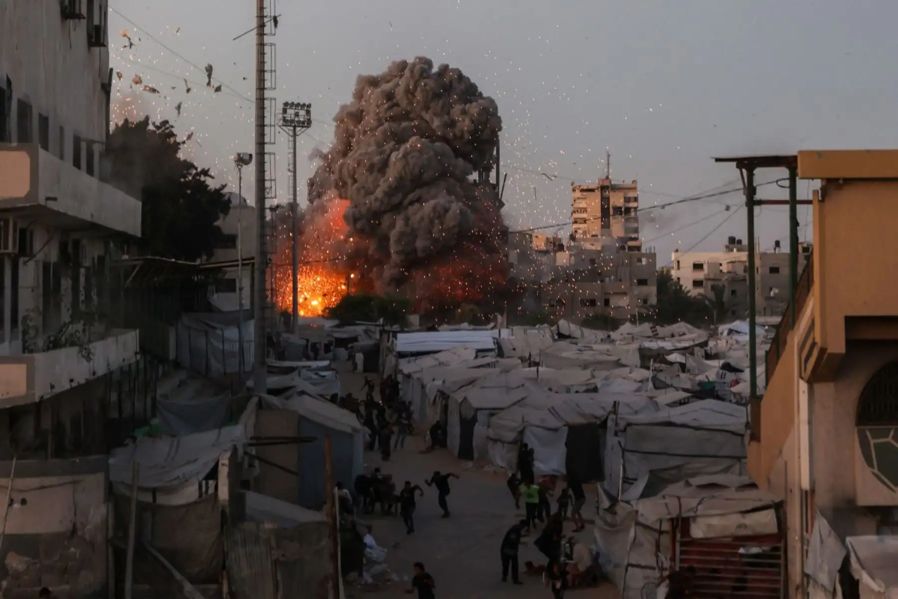 Palestinos buscan refugio mientras el humo y el fuego se elevan durante un ataque israelí contra la mezquita Al-Muttaqin en la ciudad de Gaza el 28 de julio de 2026. Foto: AFP