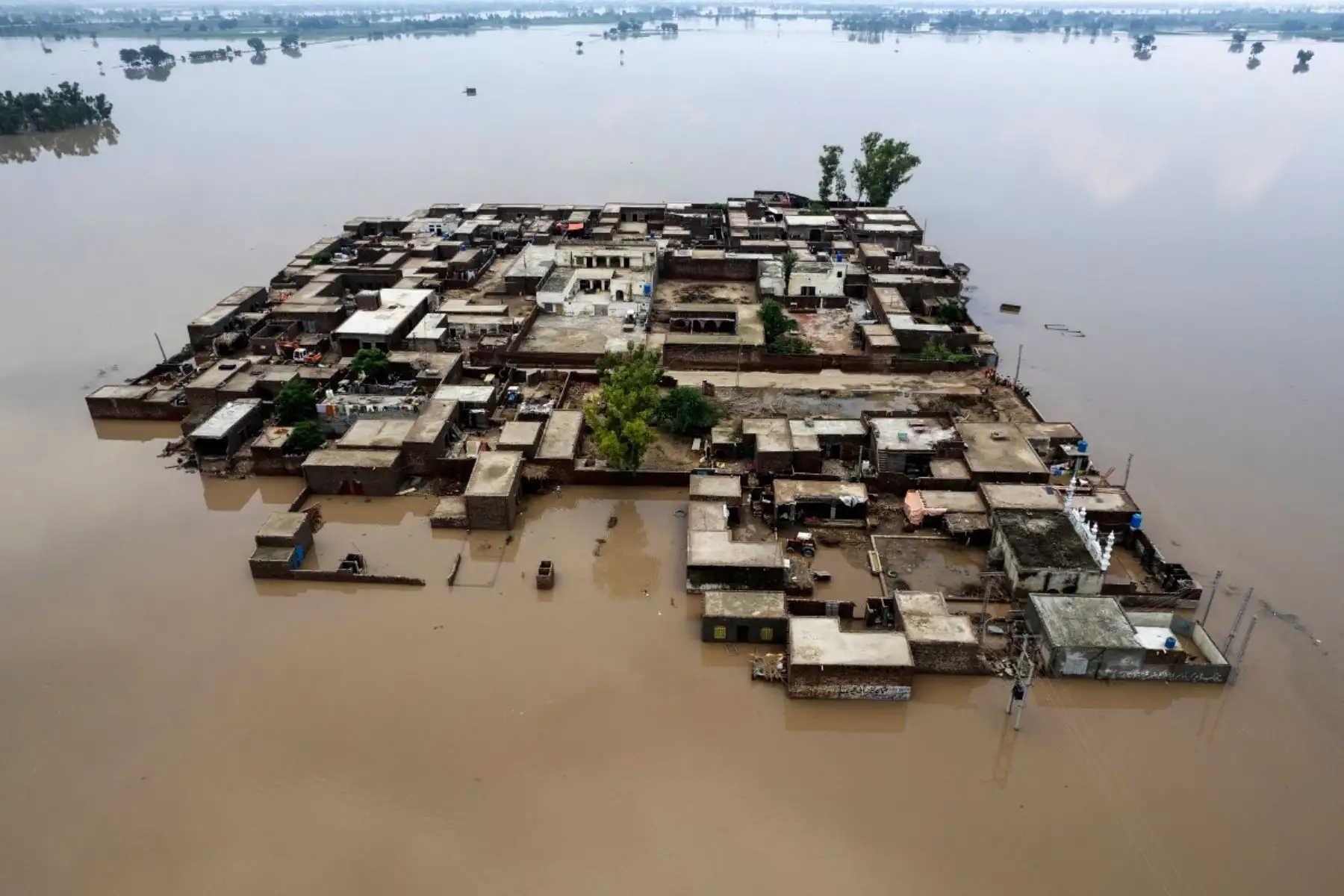 Una vista aérea muestra edificios residenciales parcialmente sumergidos en las aguas de la inundación tras las fuertes lluvias monzónicas que provocaron una crecida del río Ravi en Muridke, Pakistán, el 27 de julio de 2026. (Foto de Arif ALI / AFP)