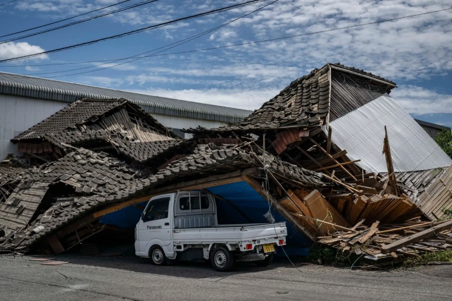Una casa se derrumbó sobre un automóvil en Yatsushiro, prefectura de Kumamoto, el 29 de julio de 2026, tras el terremoto que sacudió el suroeste de Japón el día anterior. (Foto de Yuichi YAMAZAKI / AFP)