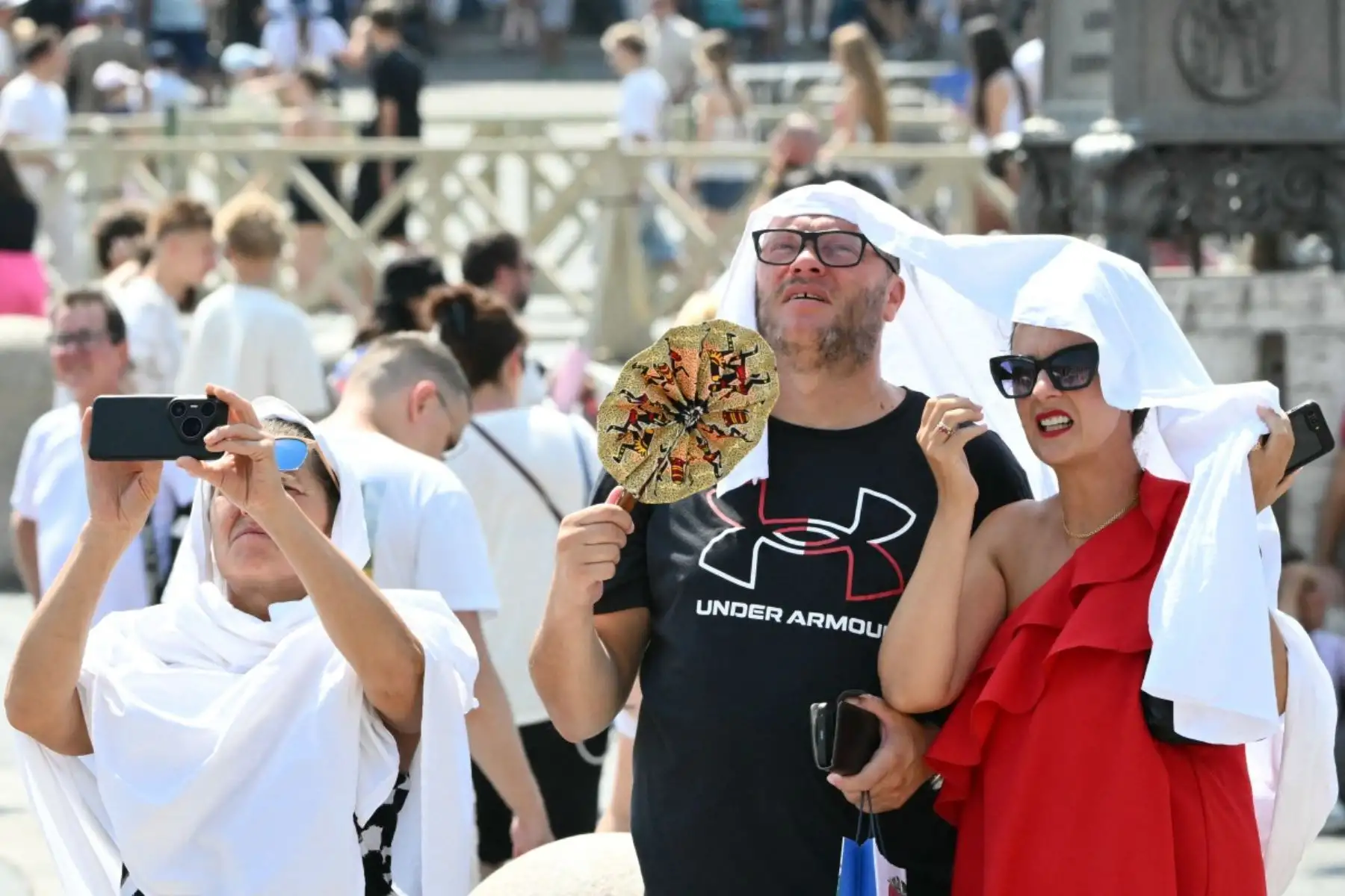 Varias personas permanecen de pie bajo el sol en la Plaza de San Pedro antes de la oración del Ángelus del Papa León XIV en el Vaticano, el 2 de agosto de 2026. (Foto de Alberto PIZZOLI / AFP)