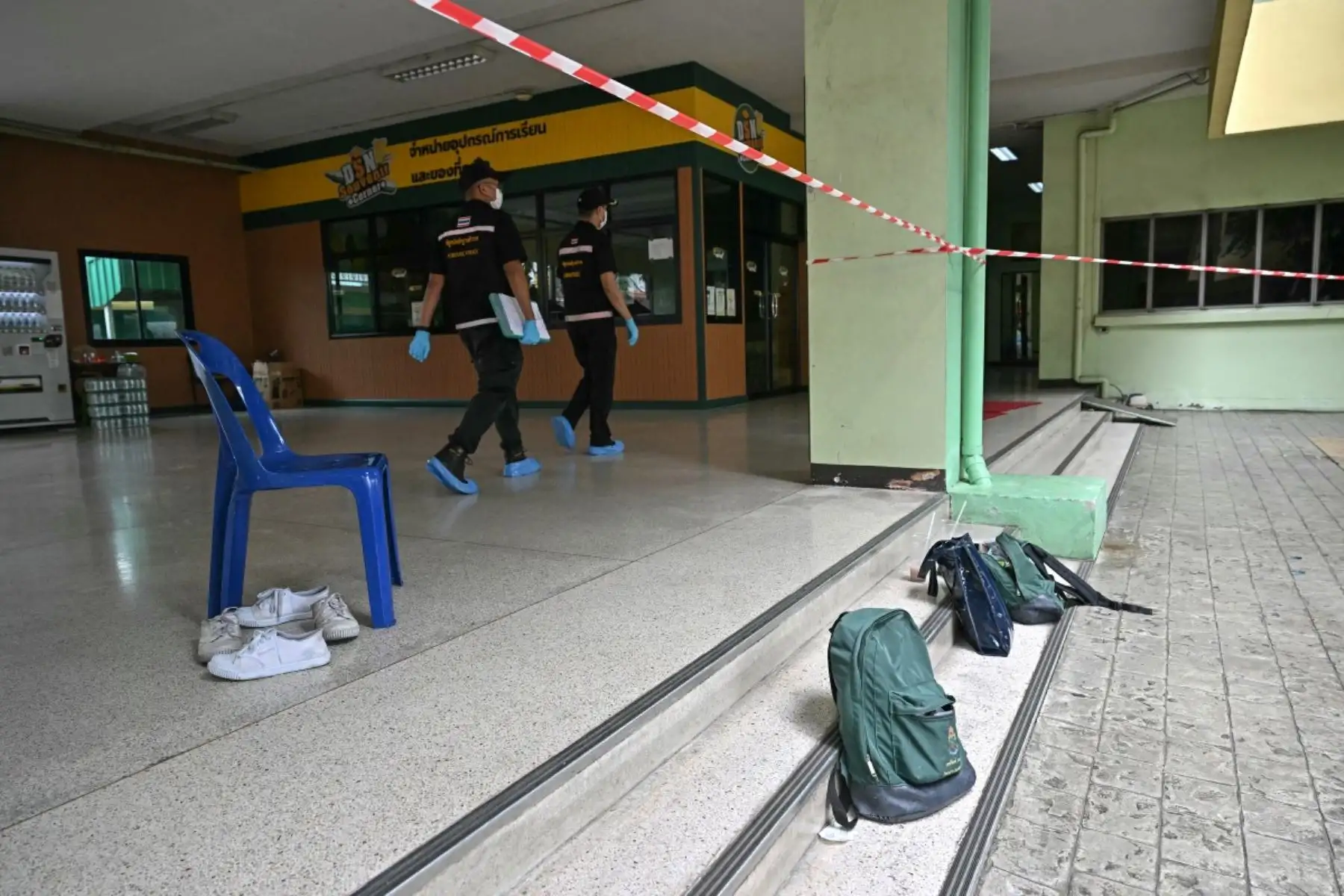 Las pertenencias de los estudiantes permanecen en el lugar de un tiroteo escolar mientras agentes de la policía forense pasan por allí, en el distrito de Bang Kruai, provincia de Nonthaburi, al norte de Bangkok, la capital de Tailandia. AFP