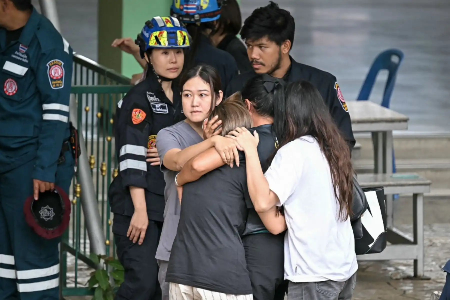 Familiares de un maestro fallecido en un tiroteo escolar son conducidos hacia una ambulancia en el distrito de Bang Kruai, provincia de Nonthaburi, al norte de Bangkok, la capital de Tailandia. AFP
