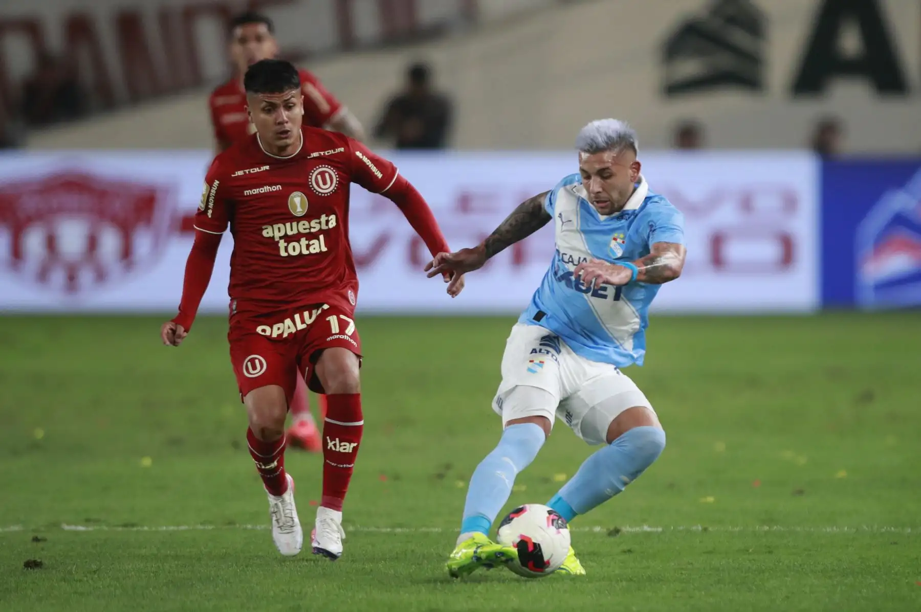 Jairo Concha de Universitario disputa el balón con el futbolista Juan Cruz González de Sporting Cristal, durante el partido perteneciente a la cuarta fecha del Torneo Clausura, en el Estadio Monumental de Lima. Foto: ANDINA/Ricardo Cuba