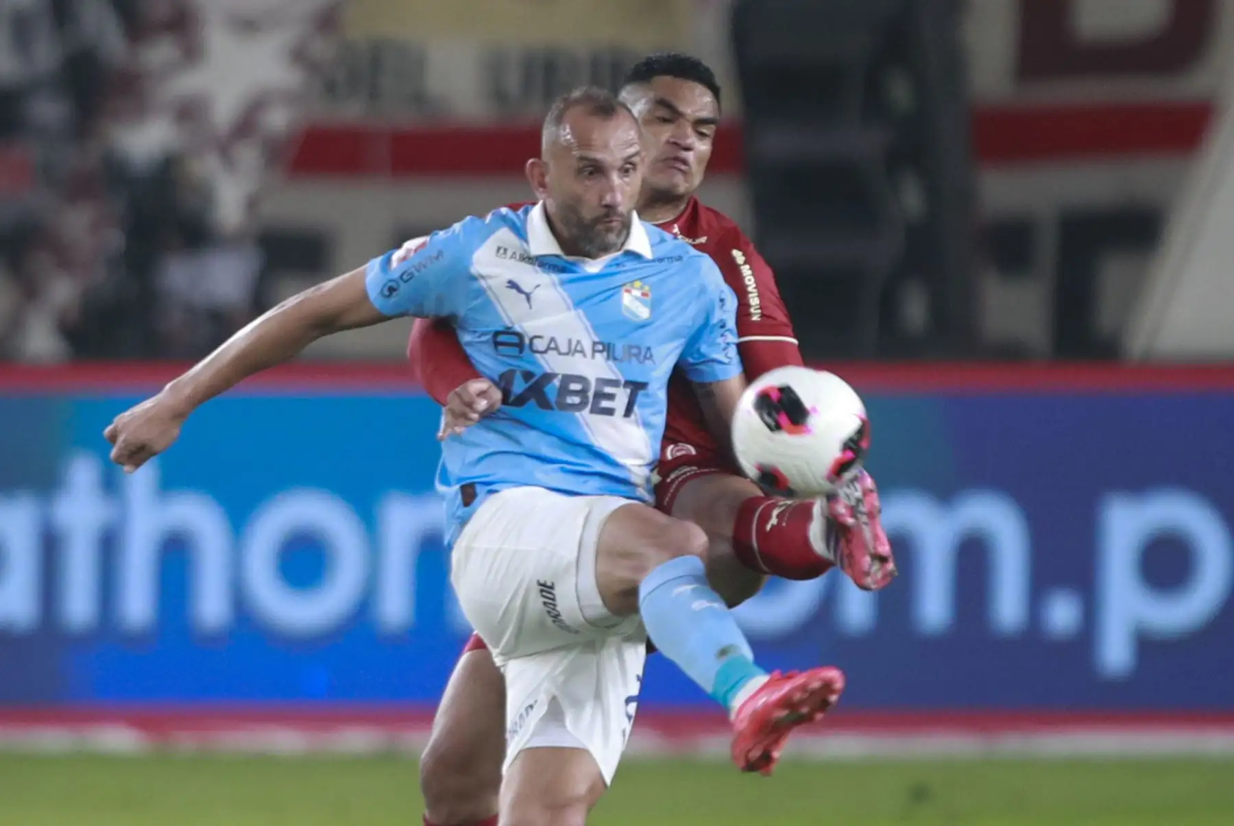 El futbolista Anderson Santa María de Universitario disputa el balón con el futbolista Hernán Barcos de Sporting Cristal, durante el partido perteneciente a la cuarta fecha del Torneo Clausura, en el Estadio Monumental de Lima. Foto: ANDINA/Ricardo Cuba