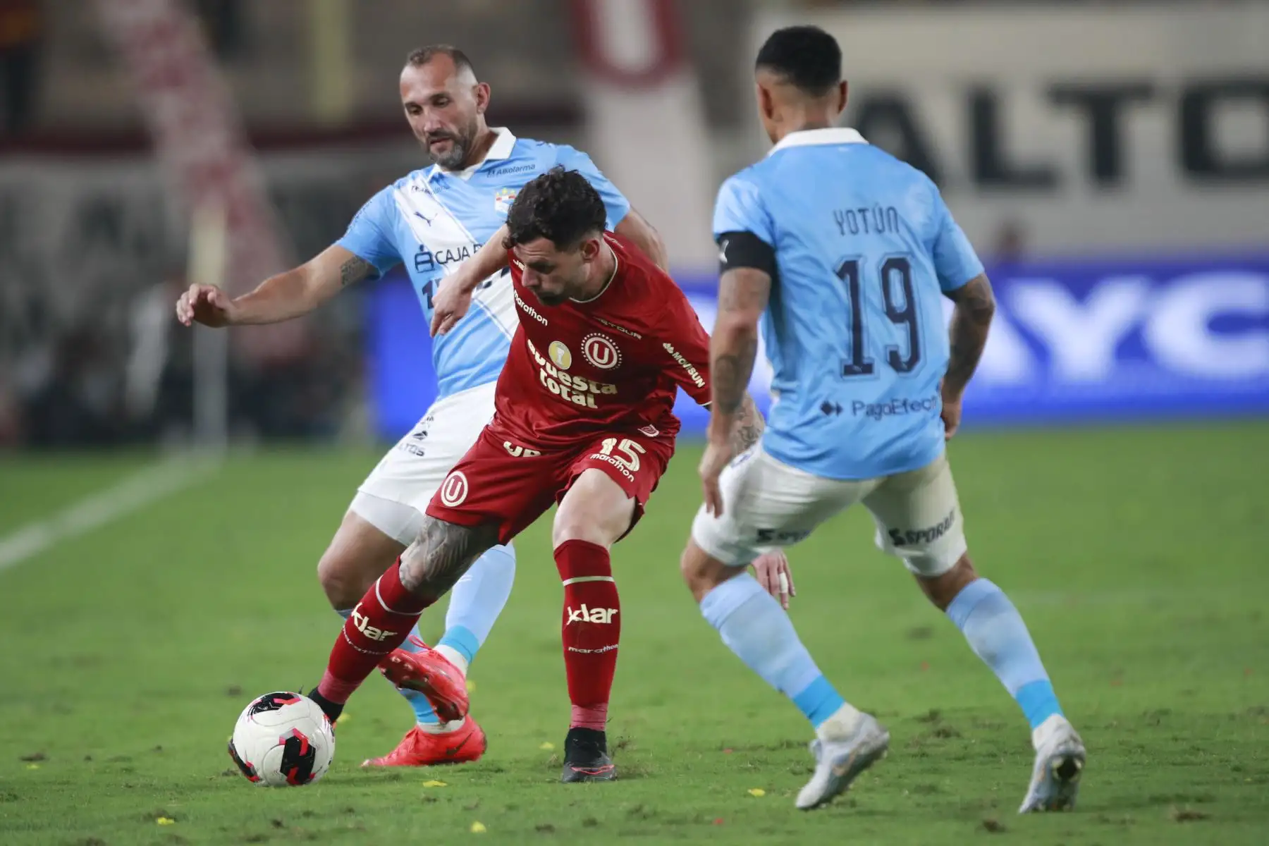 El futbolista de Universitario Juan Manuel Requena disputa el balón con el futbolista Yoshimar Yotún de Sporting Cristal, durante el partido perteneciente a la cuarta fecha del Torneo Clausura, en el Estadio Monumental de Lima. Foto: ANDINA/Ricardo Cuba