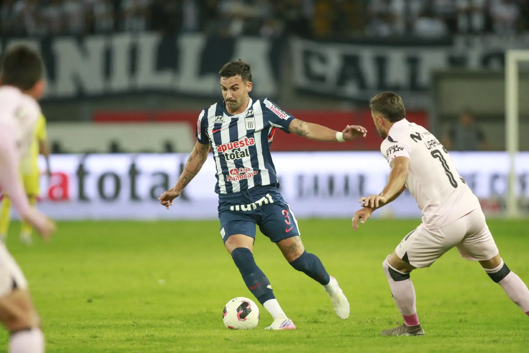 El futbolista Antoni de Alianza Lima disputa el balón con el futbolista Urruti de Sport Boys, durante el partido perteneciente a la cuarta fecha del Torneo Clausura, en el Estadio Nacional. Foto: ANDINA/Ricardo Cuba