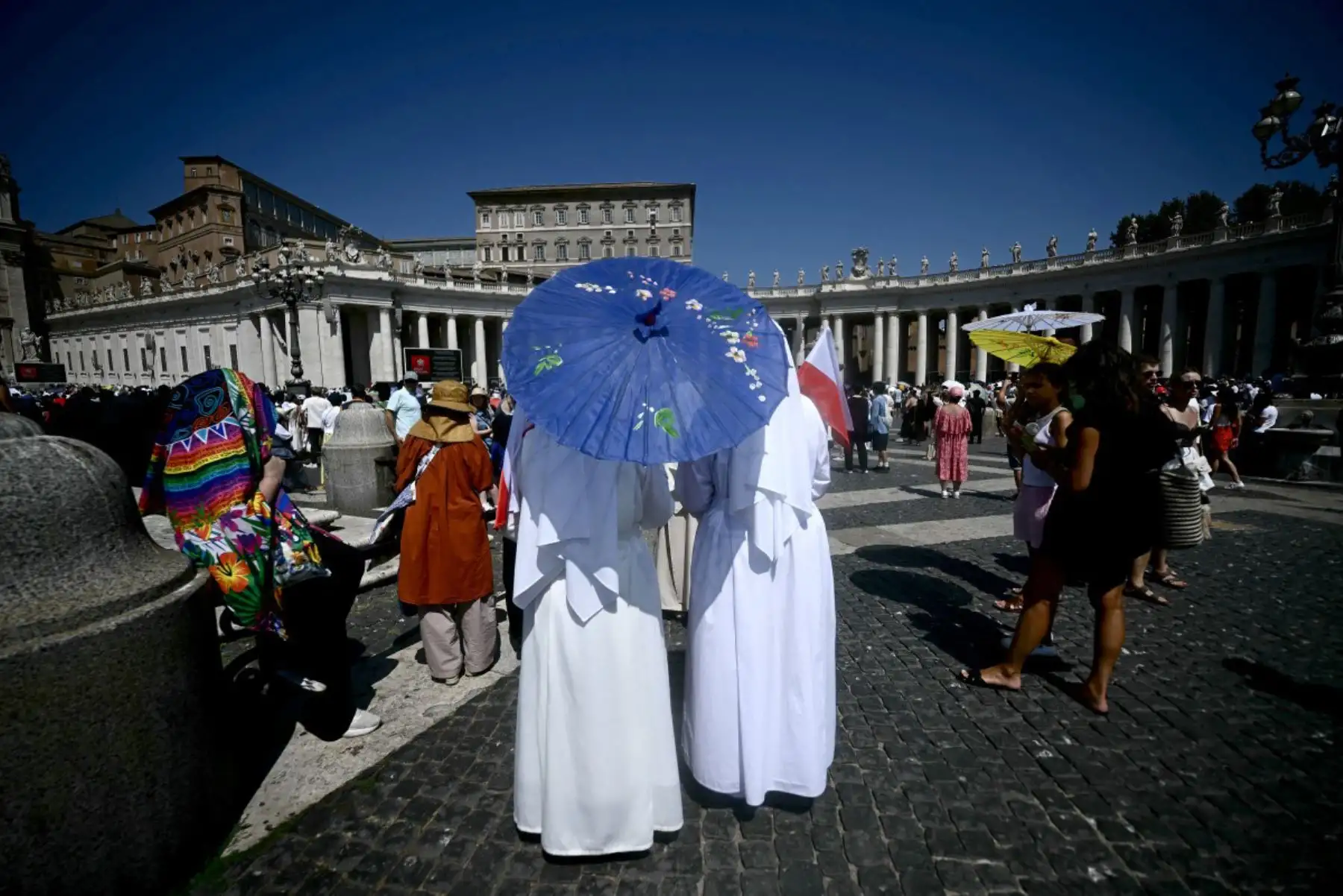 Monjas se protegen del sol del mediodía con paraguas mientras se congregan en la Plaza de San Pedro, en el Vaticano, antes de escuchar el rezo del Ángelus del Papa León XIV. Foto: ANDINA/AFP