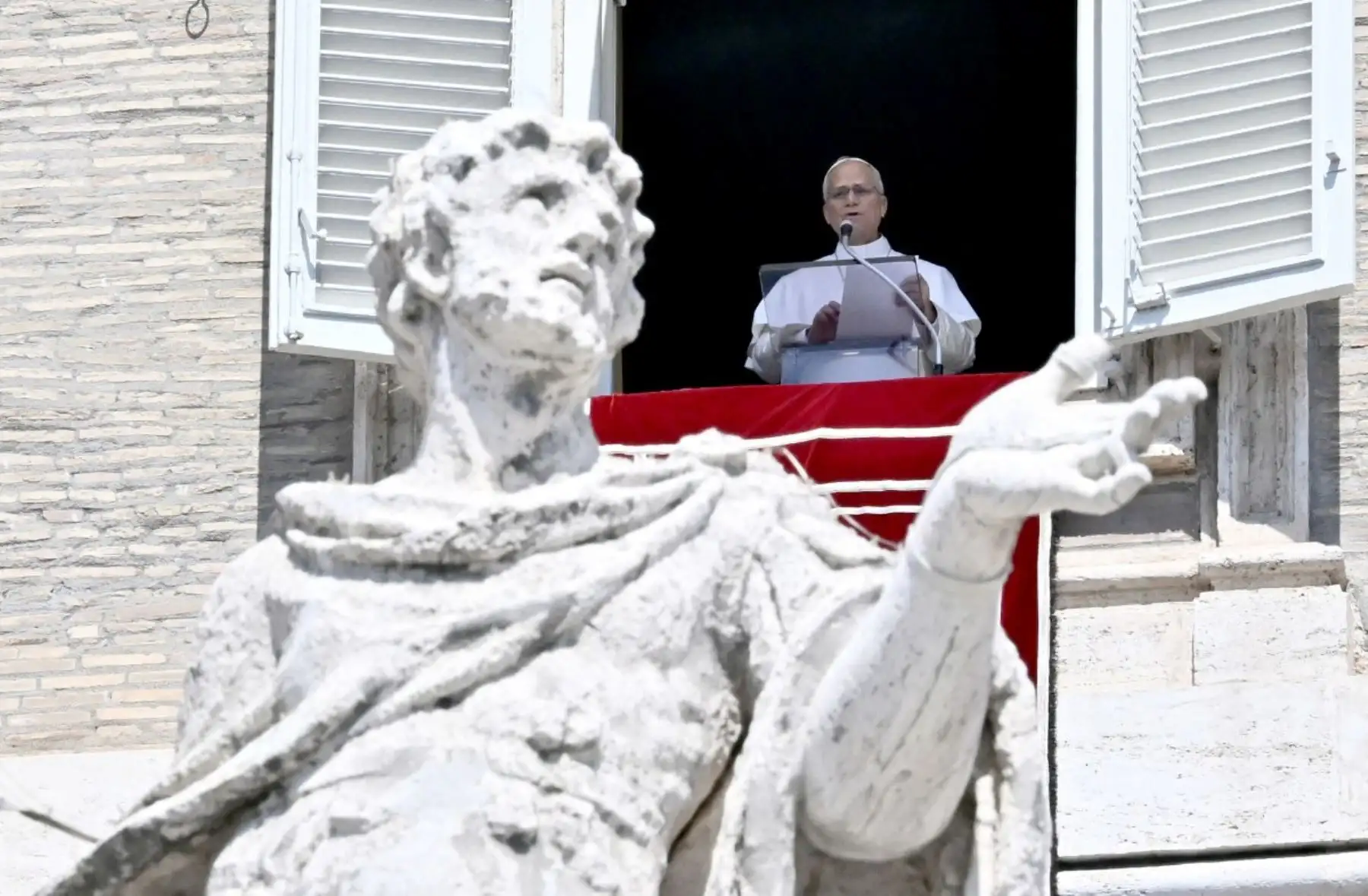 El papa León XIV pronuncia su discurso durante el rezo del Ángelus desde un balcón con vistas a la Plaza de San Pedro en el Vaticano. Foto: ANDINA/AFP
