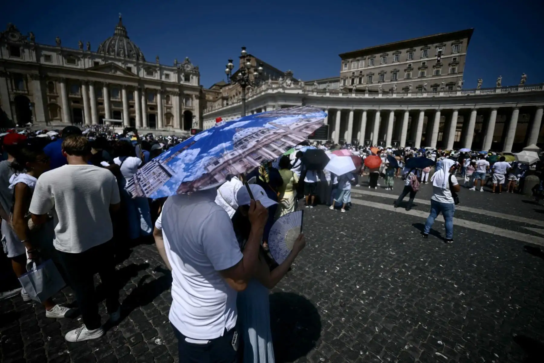 Los peregrinos se protegen del sol del mediodía con paraguas mientras se congregan en la Plaza de San Pedro, en el Vaticano, antes de escuchar el rezo del Ángelus del Papa León XIV. 
Foto: ANDINA/AFP