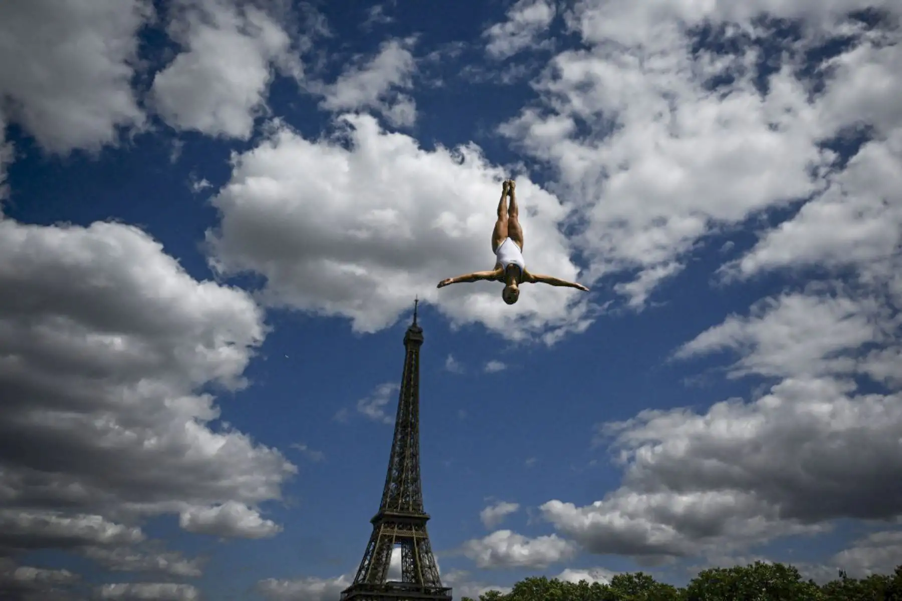 Una atleta salta desde la plataforma de 20 metros femenina durante un entrenamiento en el Campeonato Europeo de Natación LEN, a orillas del río Sena, con la Torre Eiffel de fondo, en París, el 5 de agosto de 2026. (Foto de JULIEN DE ROSA / AFP)