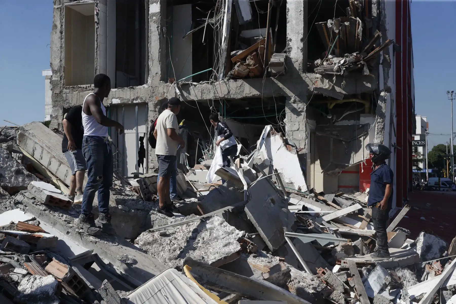 Personas caminan sobre los escombros de un edificio colapsado este lunes, en Cali (Colombia). Al menos 20 edificios sufrieron graves daños por consecuencia del terremoto de magnitud 7,4 que sacudió la mayor parte del país, con epicentro en la zona del Pacífico. Foto: EFE
