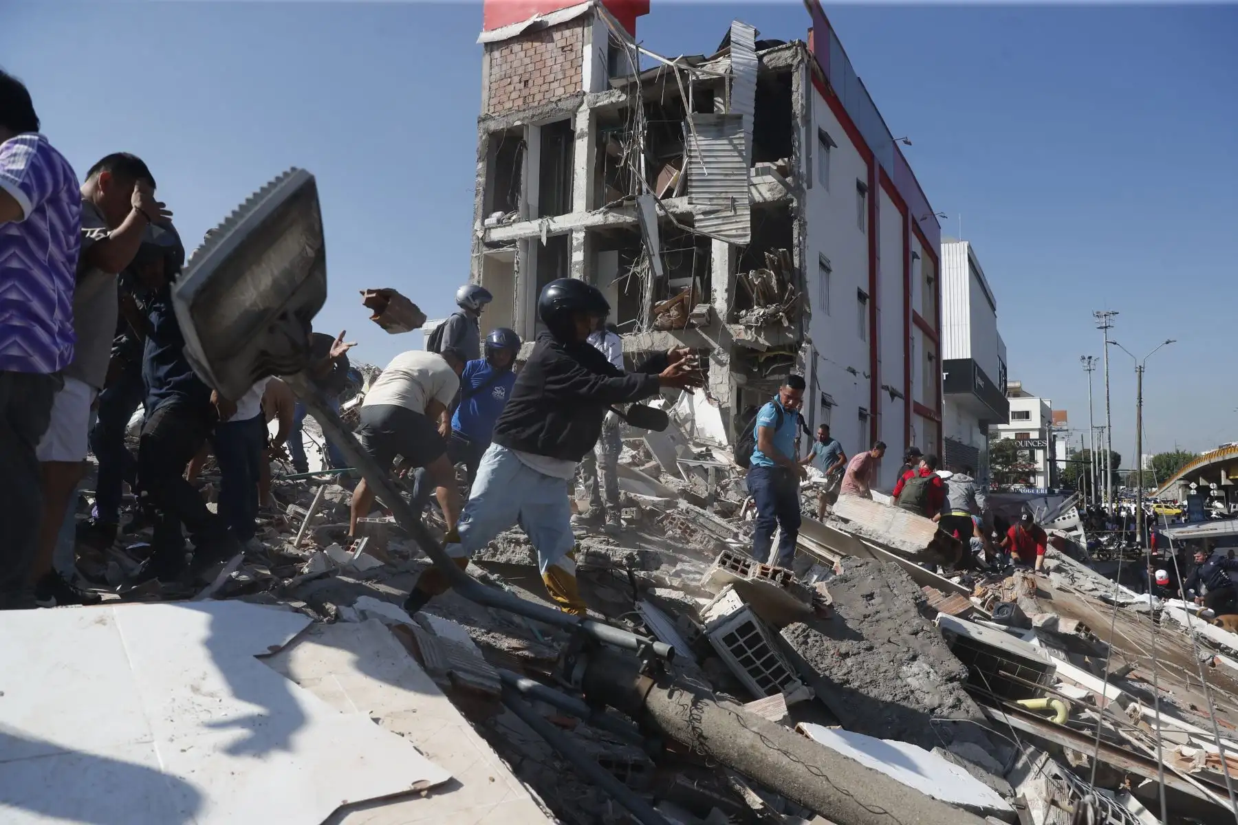 Personas caminan sobre los escombros de un edificio colapsado este lunes, en Cali (Colombia). Al menos 20 edificios sufrieron graves daños por consecuencia del terremoto de magnitud 7,4 que sacudió la mayor parte del país, con epicentro en la zona del Pacífico. Foto: EFE