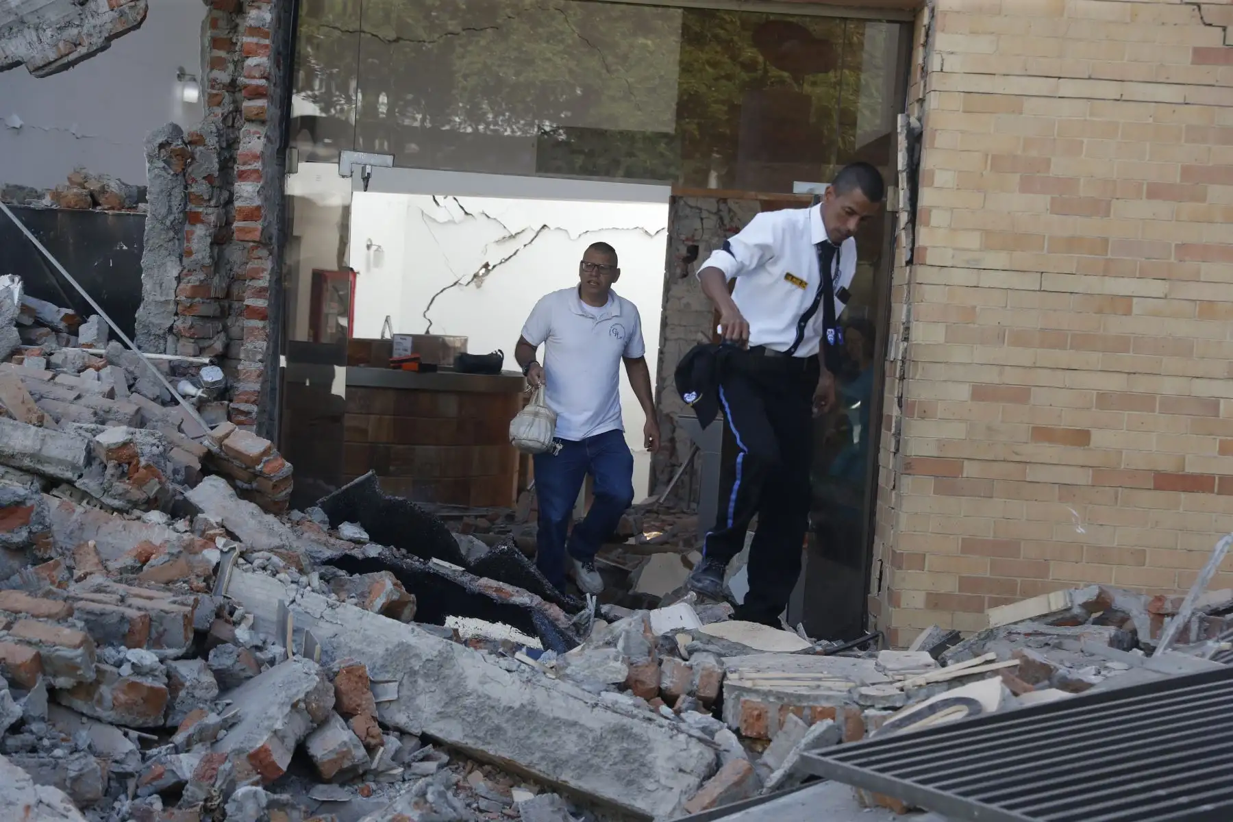 Personas caminan sobre los escombros de un edificio colapsado este lunes, en Cali (Colombia). Al menos 20 edificios sufrieron graves daños por consecuencia del terremoto de magnitud 7,4 que sacudió la mayor parte del país, con epicentro en la zona del Pacífico. Foto: EFE