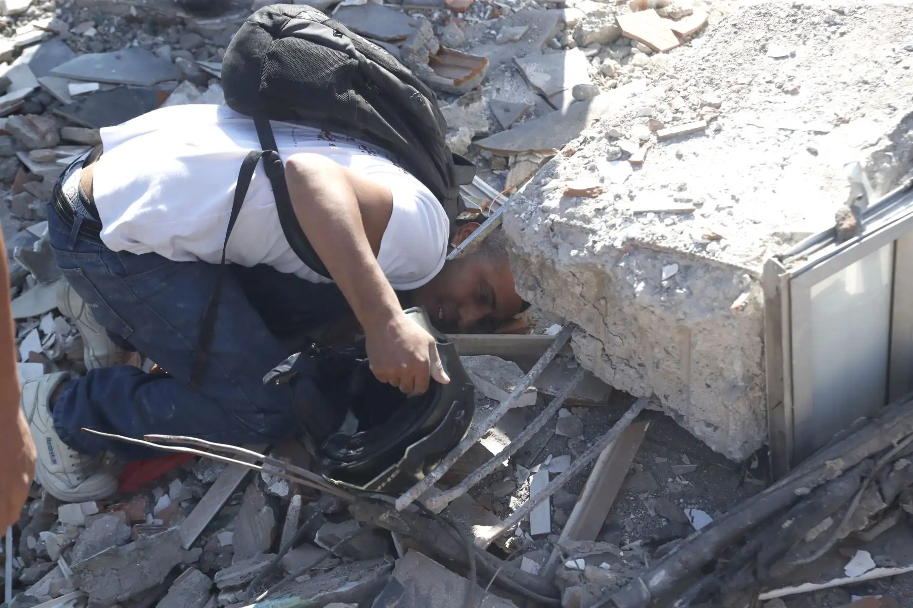 Una persona busca en los escombros de un edificio colapsado este lunes, en Cali (Colombia). Al menos 20 edificios sufrieron graves daños por consecuencia del terremoto de magnitud 7,4 que sacudió la mayor parte del país, con epicentro en la zona del Pacífico. Foto: EFE