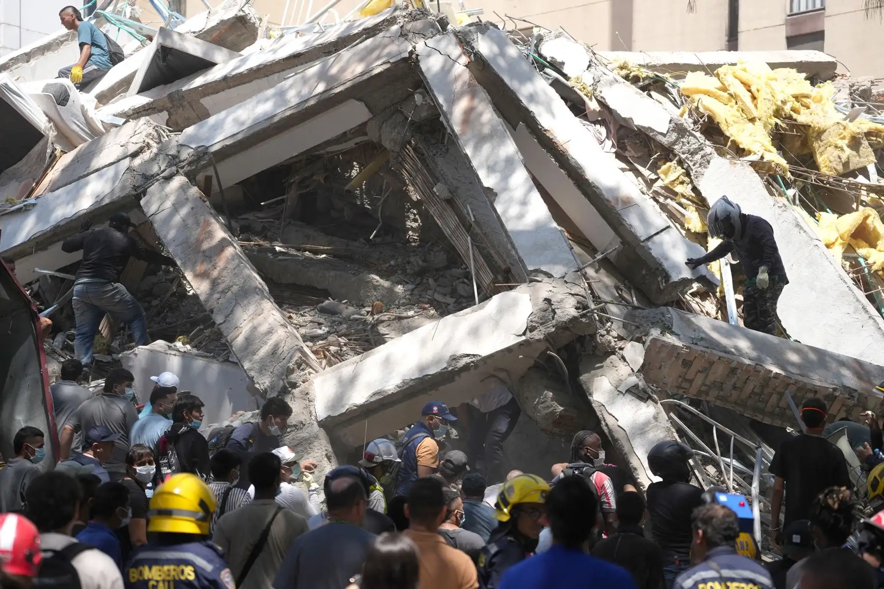 Integrantes del cuerpo de Bomberos de Cali y civiles buscan entre los escombros de edificaciones colapsadas por el terremoto de magnitud 7,4 que sacudió esta mañana el país, este lunes en Cali. El Gobierno colombiano declaró la situación de "desastre nacional" por el terremoto que deja al menos 71 personas fallecidas en el país, 29 de ellas en ciudades capitales. Foto: EFE