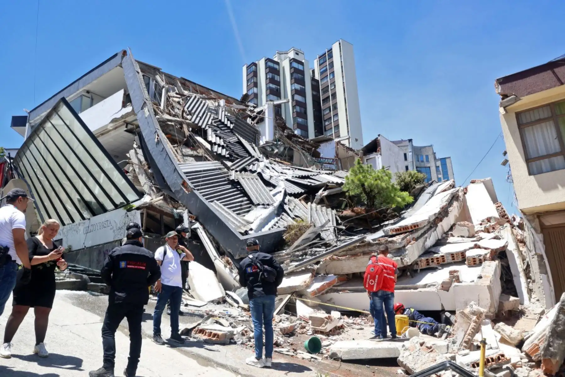 Personas transitan cerca de un edificio derrumbado tras el terremoto en Manizales, Colombia, el 10 de agosto de 2026. Equipos médicos acudieron rápidamente a ayudar a las víctimas. Foto: AFP