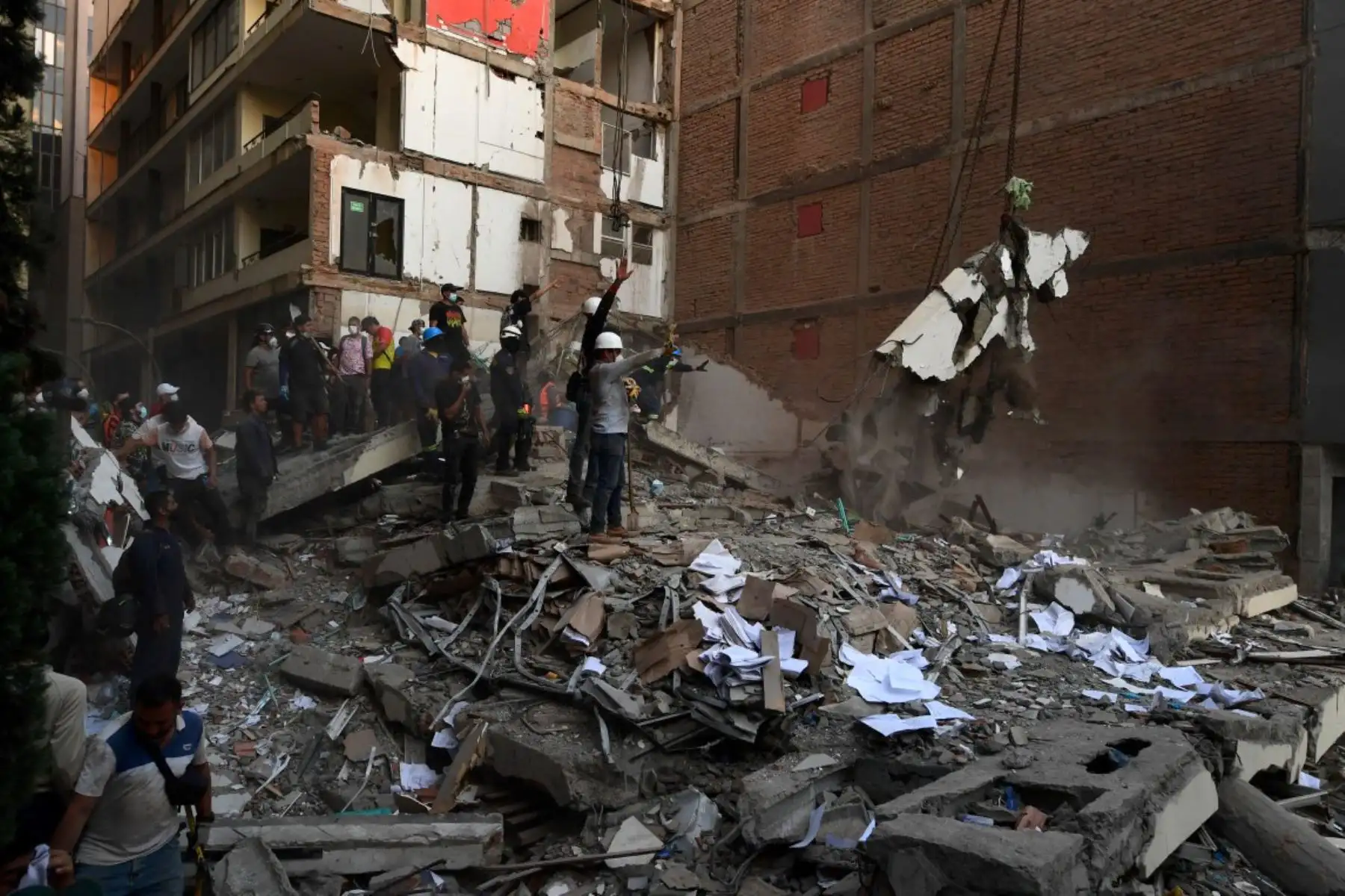 Equipos de rescate y residentes locales retiran escombros y buscan sobrevivientes entre los restos de un edificio colapsado tras el terremoto en Pereira, Colombia. Foto: AFP