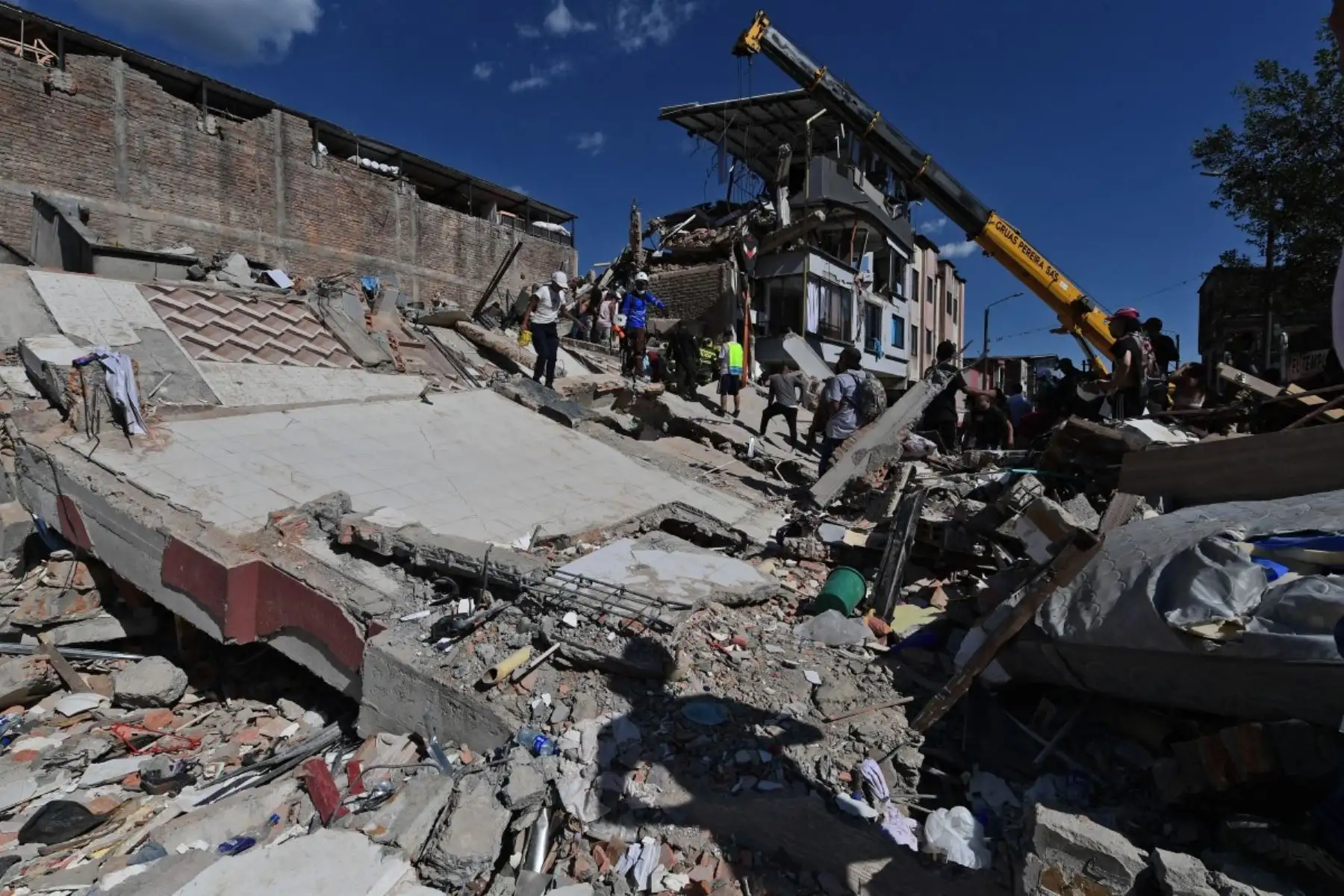 Se utiliza maquinaria pesada para retirar los escombros de un edificio colapsado tras el terremoto en Pereira, Colombia. Equipos médicos acudieron rápidamente a asistir a las víctimas. Foto: AFP
