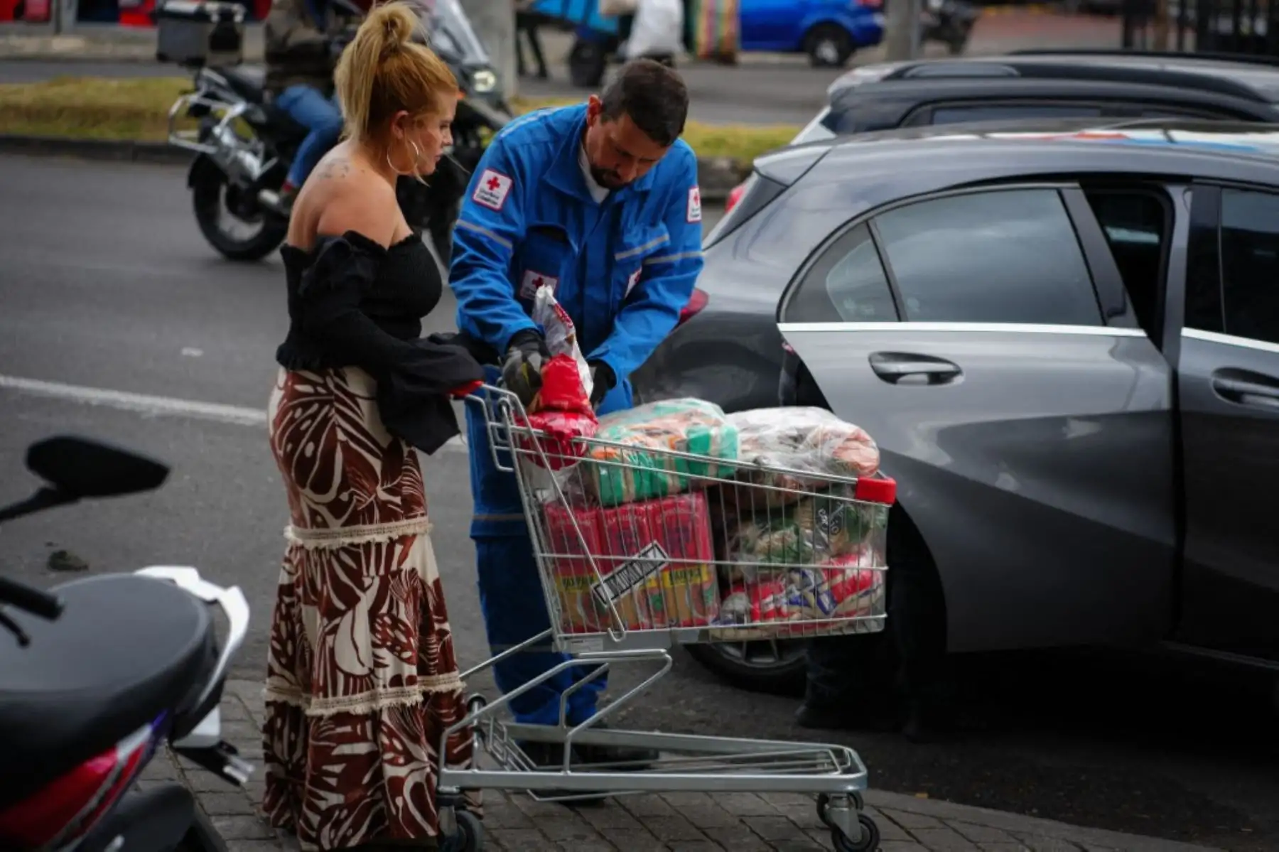 Un funcionario de la Cruz Roja Colombiana recibe ayuda humanitaria de una mujer en un centro de acopio en Bogotá, Colombia, el 11 de agosto de 2026. Las donaciones se enviarán a las comunidades afectadas por el terremoto que sacudió Colombia el 10 de agosto, causando daños y afectando a varias ciudades del país. Foto: AFP