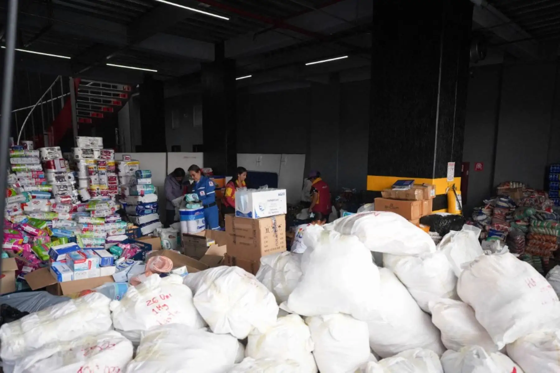 Personas clasifican ayuda humanitaria en un centro de acopio operado por la Cruz Roja Colombiana en Bogotá, Colombia, el 11 de agosto de 2026. Las donaciones se enviarán a las comunidades afectadas por el terremoto que sacudió Colombia el 10 de agosto, causando daños y afectando a varias ciudades del país. Foto: AFP