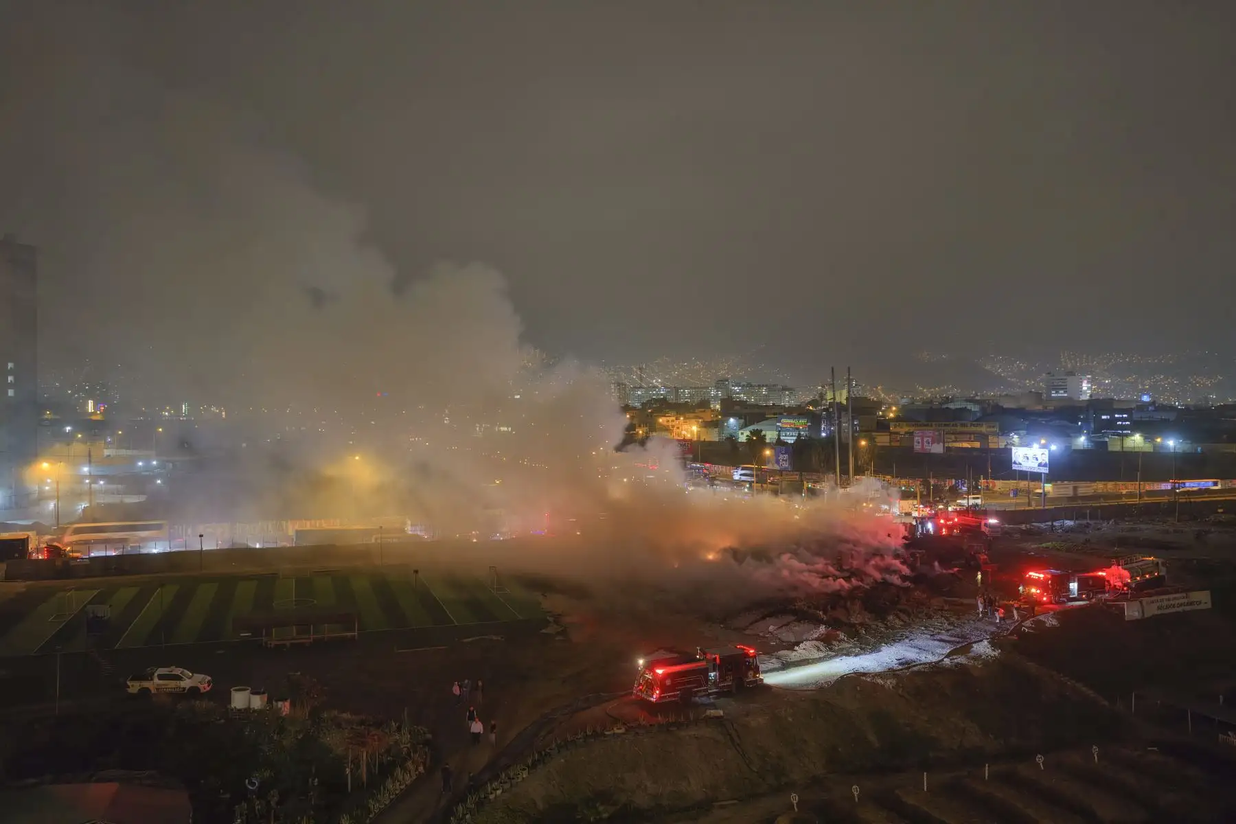 Un incendio de grandes proporciones se registra esta noche en el vivero municipal de Los Olivos, ubicado en el cruce de las avenidas Alfredo Mendiola y Próceres, cerca de la Panamericana Norte. El siniestro ha generado una extensa columna de humo visible desde distintos puntos de la zona. Seis unidades del Cuerpo General de Bomberos se encuentran en el lugar para controlar las llamas y evitar que el fuego se propague a áreas aledañas. Foto: ANDINA/Melina Mejía