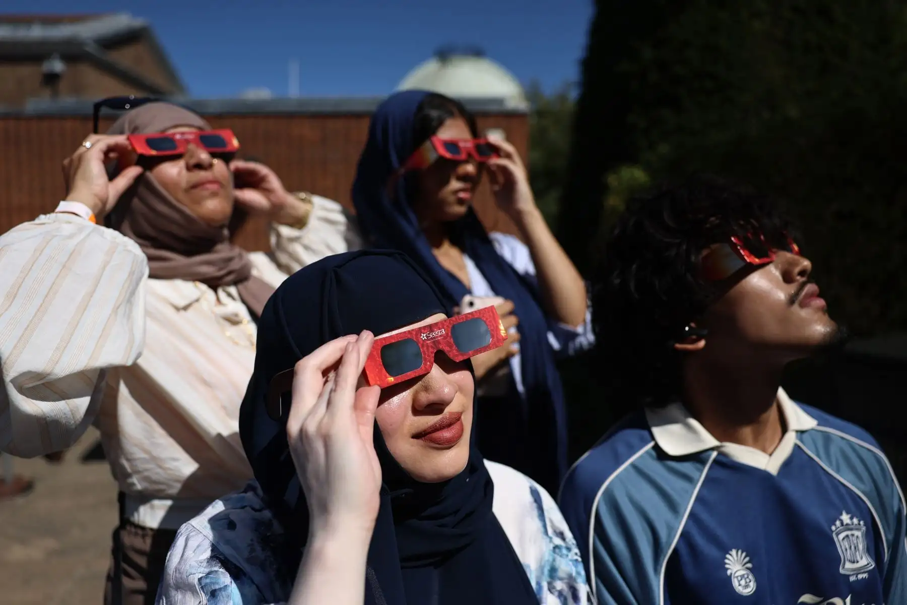 Personas se protegen los ojos con gafas especiales durante un eclipse en el Observatorio de Greenwich, en Londres. Foto: EFE