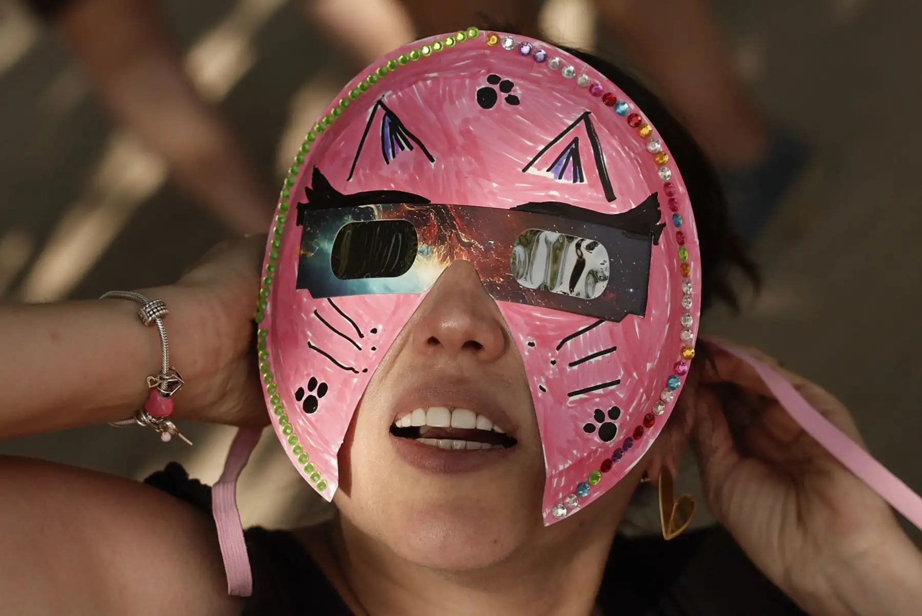 Una persona con máscara y gafas espera el eclipse de Sol en Madrid. Foto: EFE