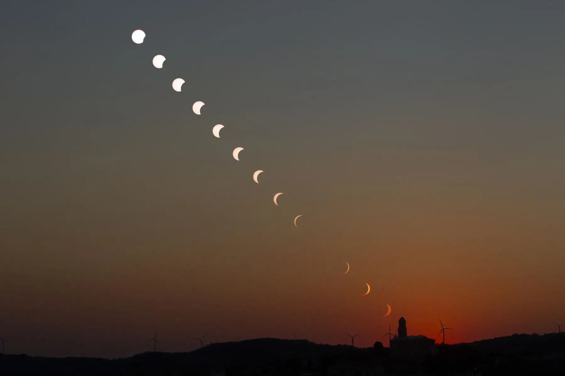 Fotomontaje creado a partir de los astros superpuestos en el momento del eclipse total de sol este miércoles sobre la iglesia de Corbera d’Ebre. Foto: EFE