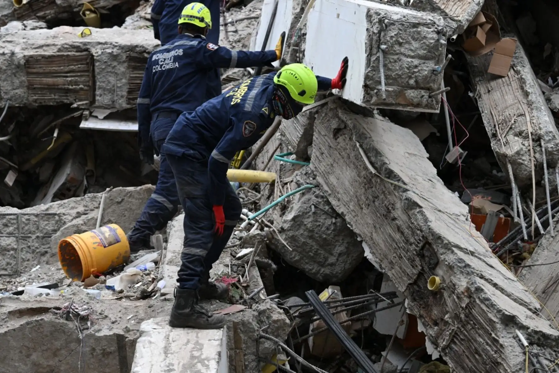 Bomberos colombianos buscan supervivientes entre los escombros de un edificio derrumbado tras un terremoto en Cali, Colombia. AFP