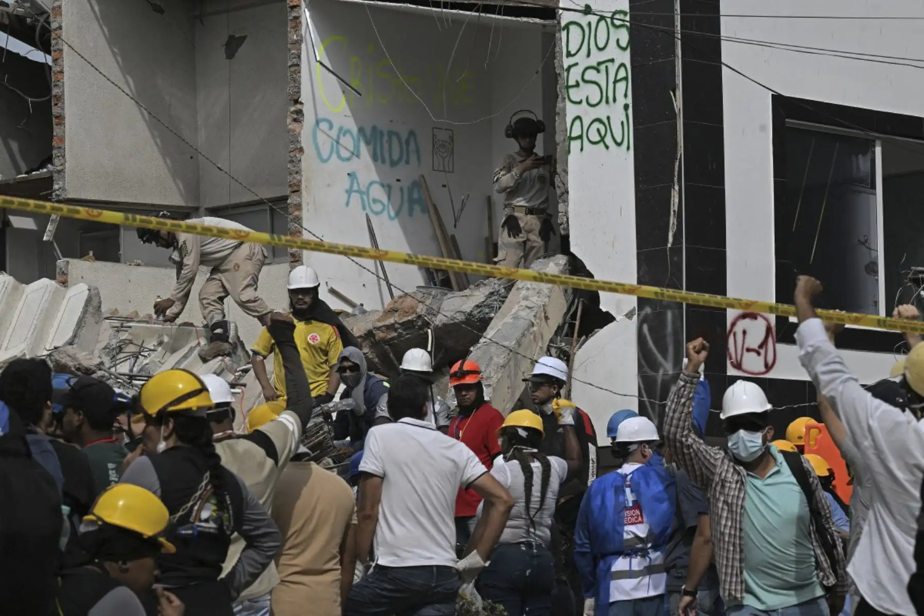 Unos voluntarios piden silencio mientras los bomberos buscan supervivientes entre los escombros de edificios colapsados ​​tras un terremoto en Cali, Colombia. 

Foto:AFP