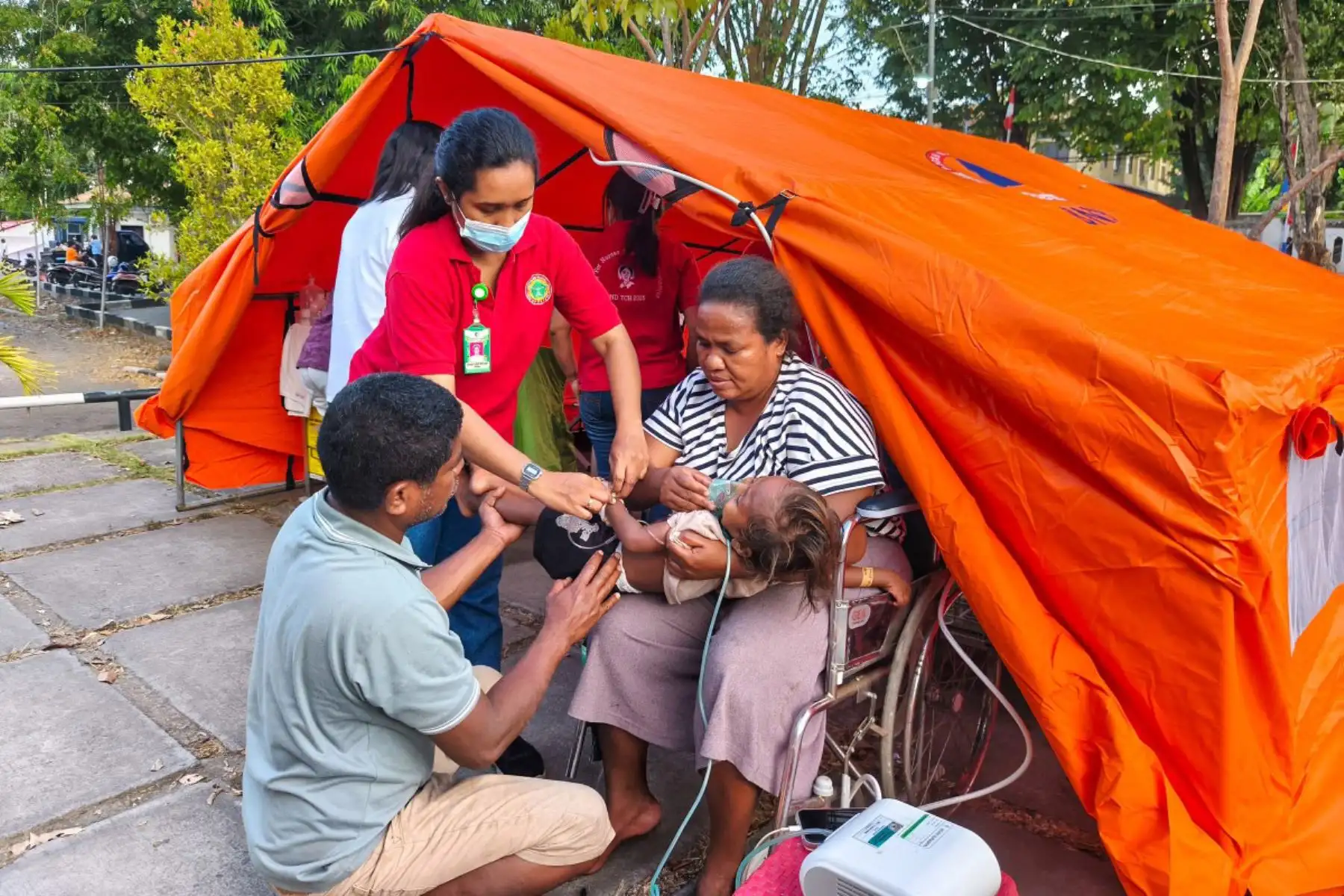 Un joven paciente recibe atención médica junto a una carpa provisional instalada por temor a réplicas en Maumere, en la isla de Flores, tras un terremoto de magnitud 7,7. Los rescatistas buscaron supervivientes entre los escombros después de que un potente terremoto sacudiera la costa de la isla de Flores. Foto: ANDINA/AFP