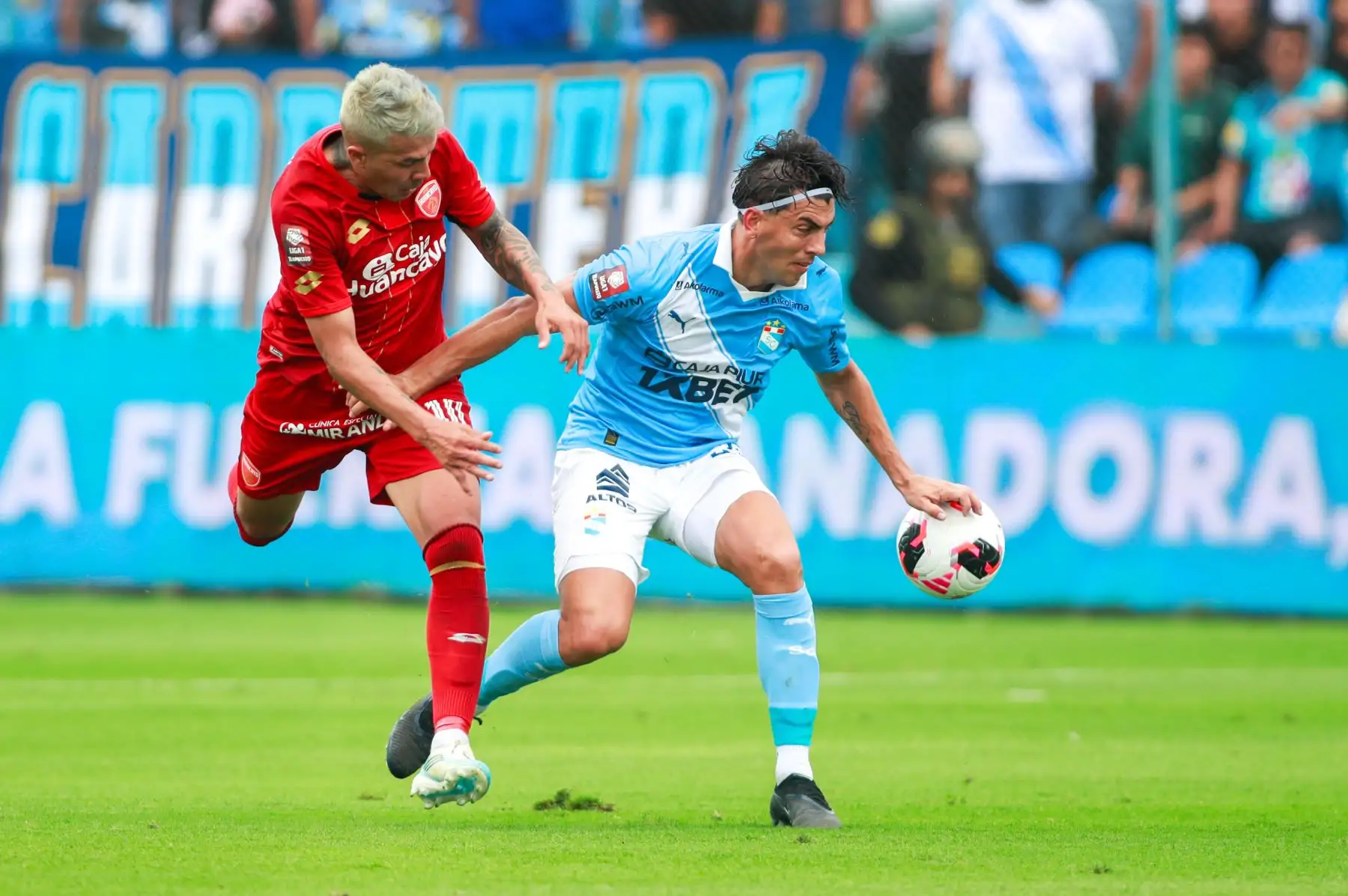 El jugador de Sporting Cristal, disputa el balón con el jugador ante Sport Huancayo, durante el partido perteneciente a la quinta fecha del Torneo Clausura, en el Estadio Gallardo del Rimac. 
Foto: ANDINA/Ricardo Cuba
