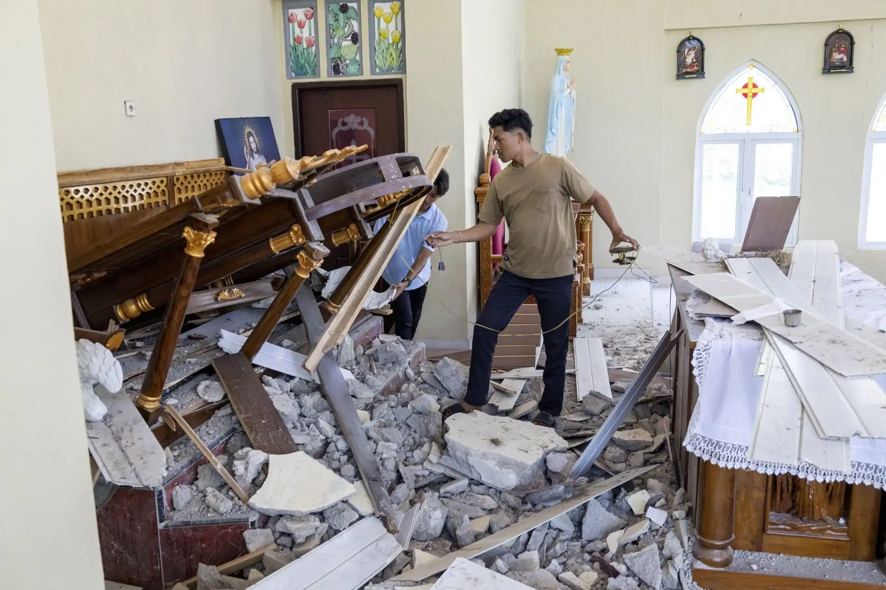 Un hombre inspecciona los daños en el interior de una iglesia tras un terremoto en la regencia de Sikka, provincia de Nusa Tenggara Oriental (Indonesia). Foto: EFE