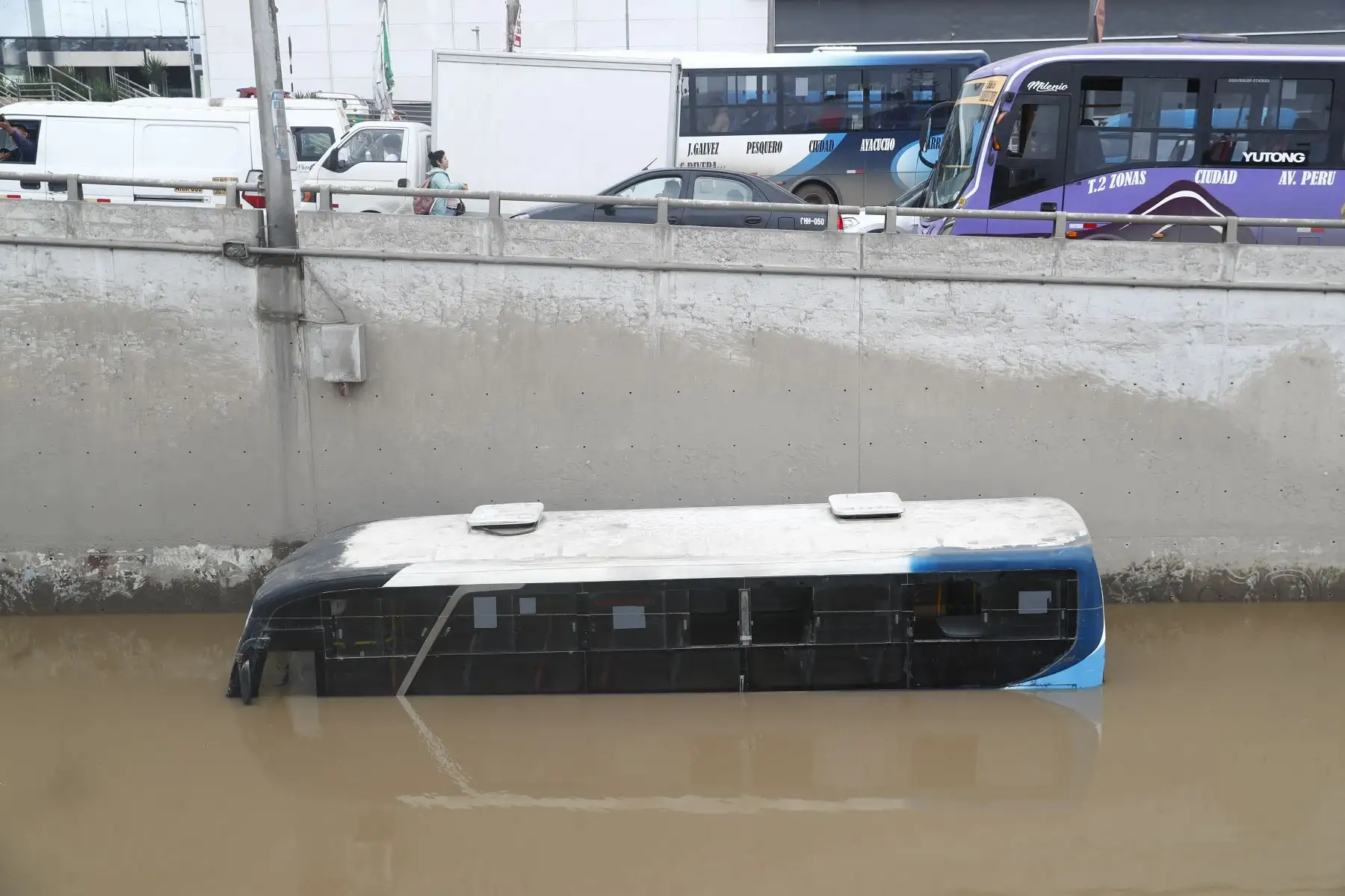 El agua acumulada cubre gran parte de una unidad de transporte público en el by pass de la avenida Pachacútec, en Villa María del Triunfo. Foto: ANDINA/Daniel Bracamonte.
