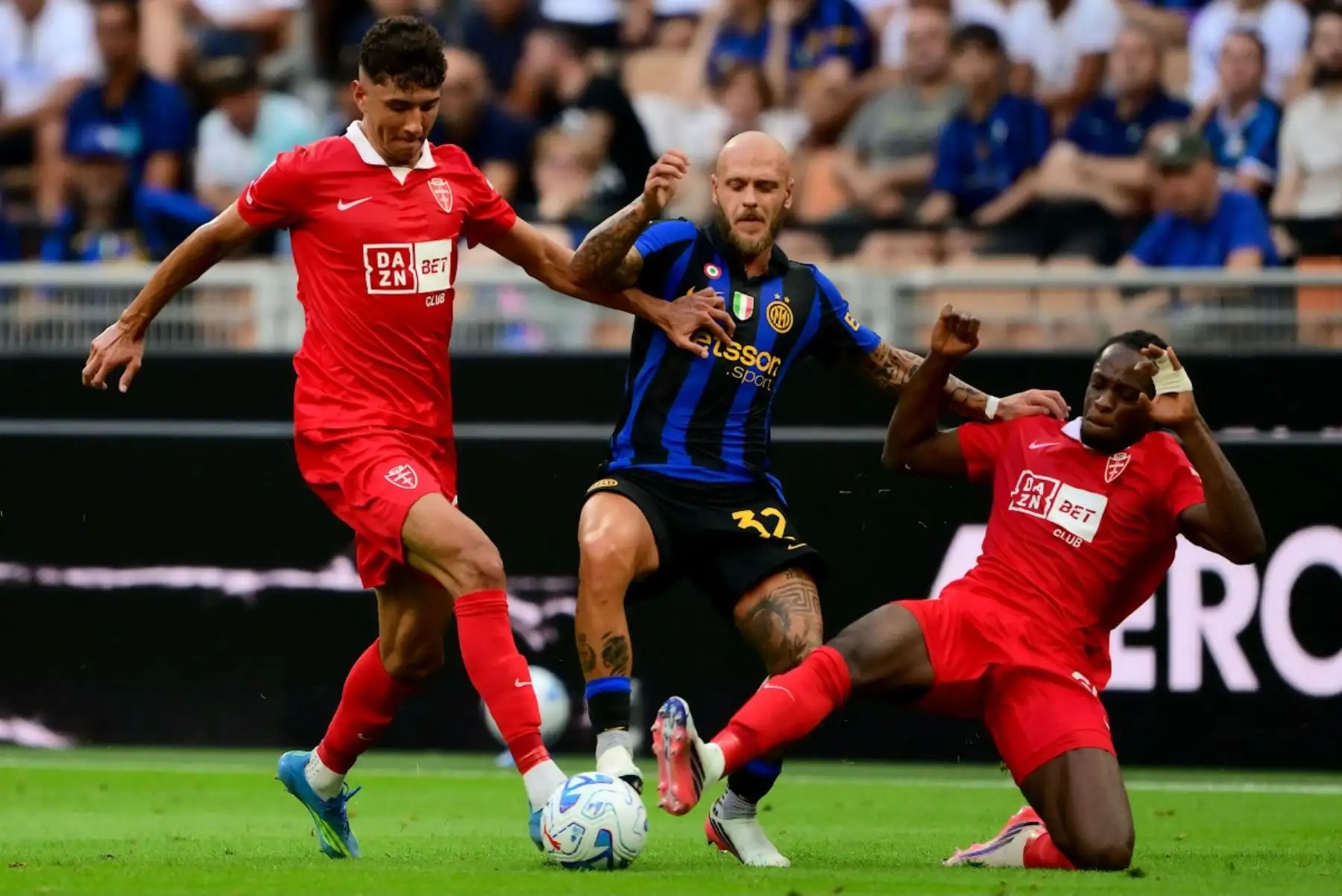 El defensa italiano del Monza, Adam Bakoune (izq.), número 24, y el defensa italiano del Monza, Eddy Kouadio (der.), número 60, luchan por el balón con el defensa italiano del Inter de Milán, Federico Dimarco (centro), número 32, durante el partido de la Serie A italiana entre el Inter de Milán y el AC Monza en el estadio San Siro de Milán, al norte de Italia, el 22 de agosto de 2026. (Foto de Marco Bertorello / AFP)