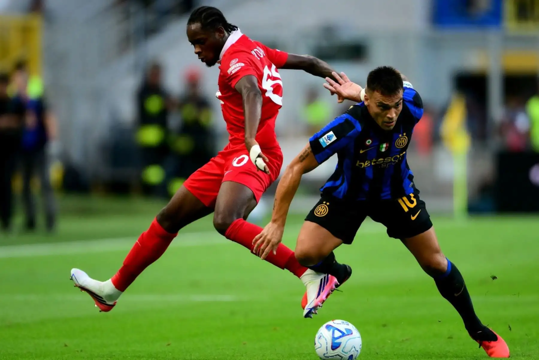 El defensa italiano del Monza, Eddy Kouadio (izq.), número 60, disputa el balón con el delantero argentino del Inter de Milán, Lautaro Martínez (izq.), número 10, durante el partido de la Serie A italiana entre el Inter de Milán y el AC Monza en el estadio San Siro de Milán, al norte de Italia, el 22 de agosto de 2026. (Foto de Marco Bertorello / AFP)