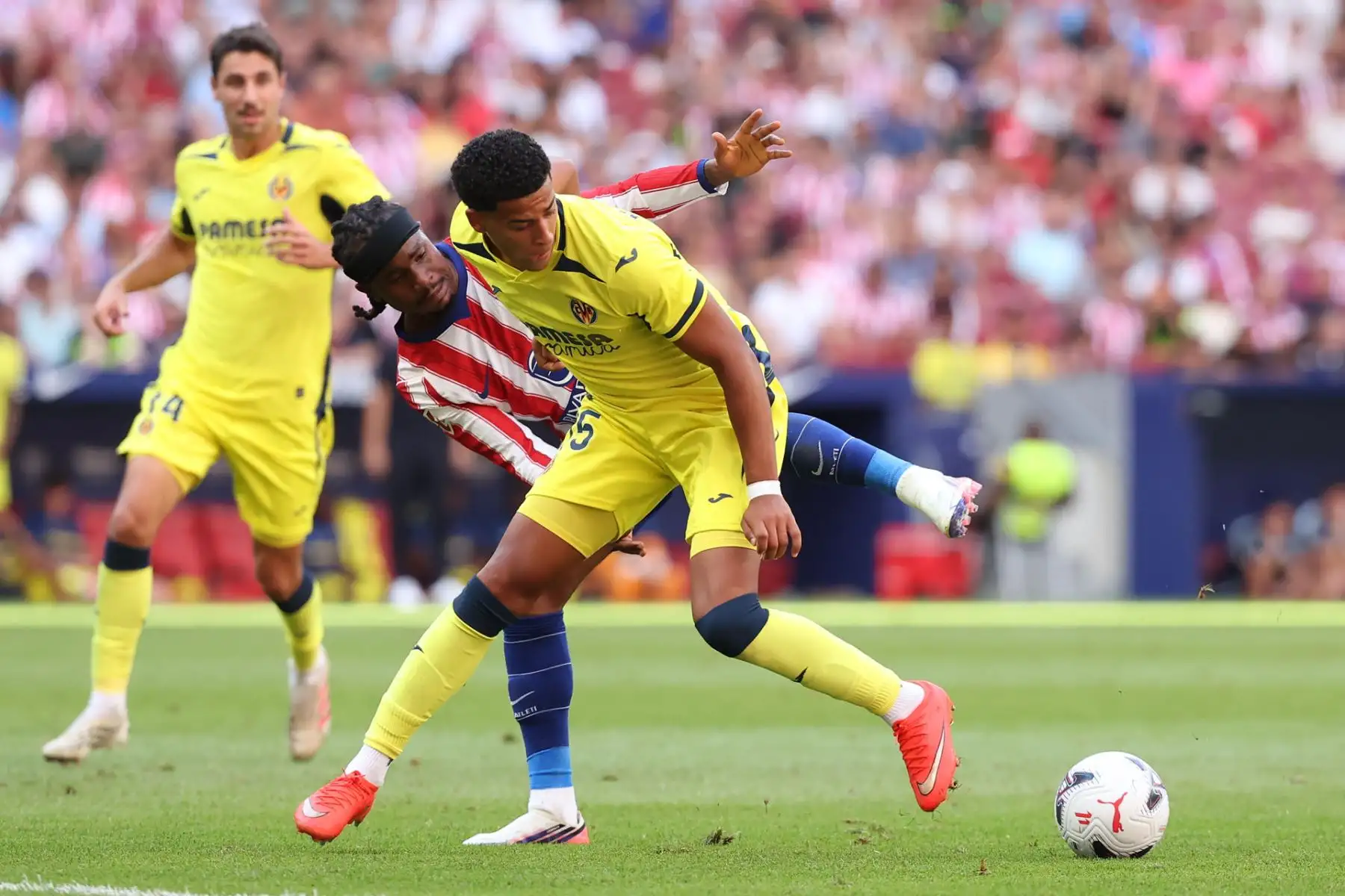 El defensa del Villarreal Santiago Mouriño (d) pelea un balón con el delantero nigeriano del Atlético de Madrid Ademola Lookman en el partido de LaLiga entre el Atlético de Madrid y el Villarreal, este domingo en el estadio Metropolitano, en Madrid. Foto: EFE