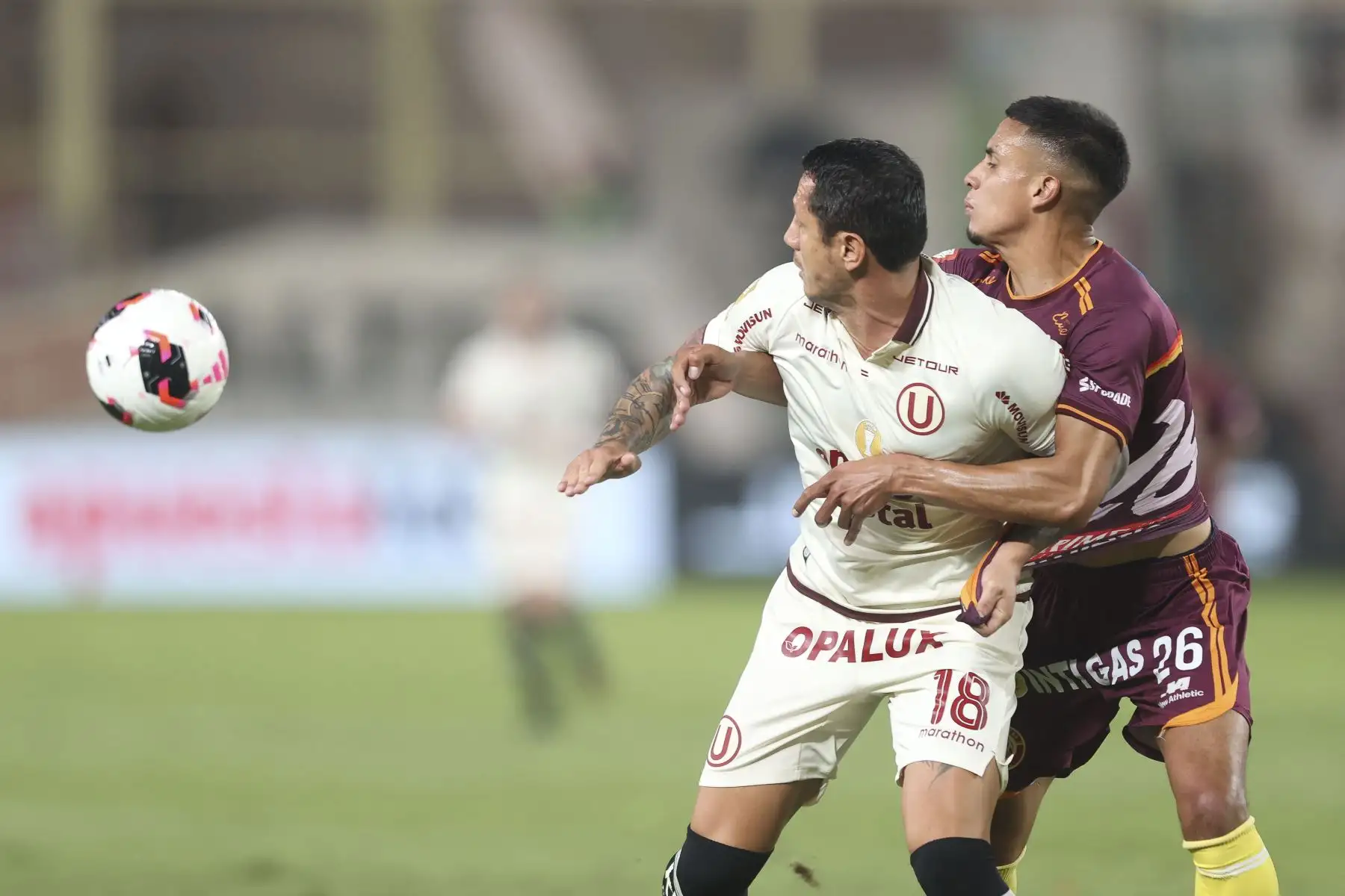El futbolista Nro. 18 de Universitario, Gianluca Lapadula, disputa el balón con el jugador Nro. 26 de Chankas, David Gonzáles, durante el partido de la fecha 6 del Torneo Clausura 2026 de la Liga 1, disputado en el Estadio Monumental U de Ate el domingo 23 de agosto. Foto: ANDINA/Jhonel Rodríguez