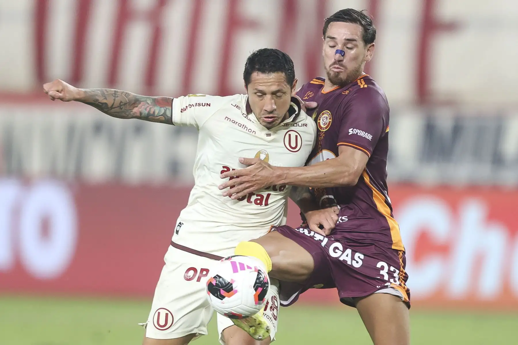 El futbolista Nro. 18 de Universitario, Gianluca Lapadula, disputa el balón con el jugador Nro. 33 de Chankas, Carlos Pimienta, durante el partido de la fecha 6 del Torneo Clausura 2026 de la Liga 1, disputado en el Estadio Monumental U de Ate el domingo 23 de agosto. Foto: ANDINA/Jhonel Rodríguez