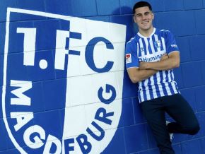Felipe Chávez posa a lado del escudo del FC Magdeburg, su nuevo club