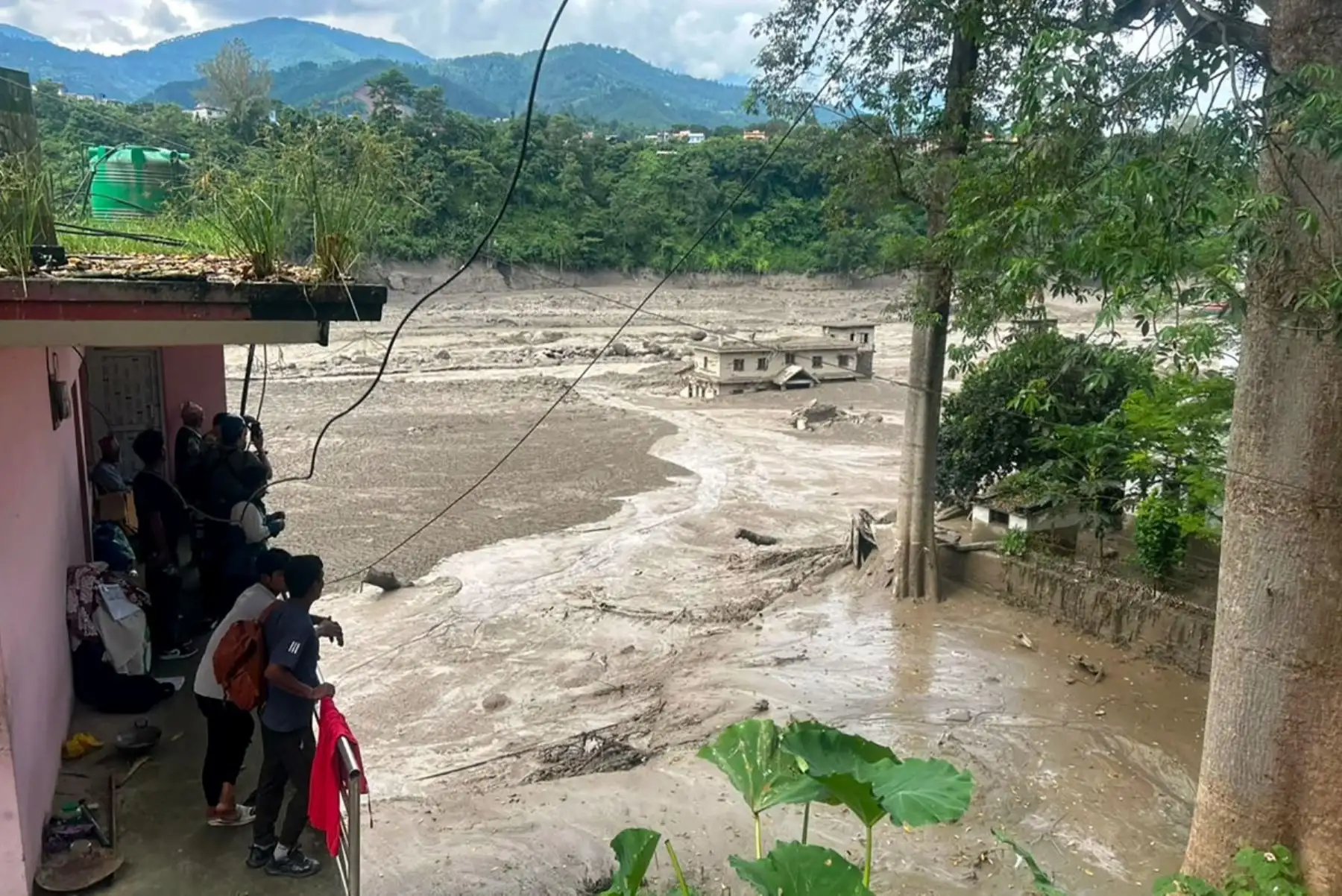 Aguas desbordadas arrastran viviendas tras las inundaciones registradas en el distrito de Rasuwa, en el norte de Nepal.