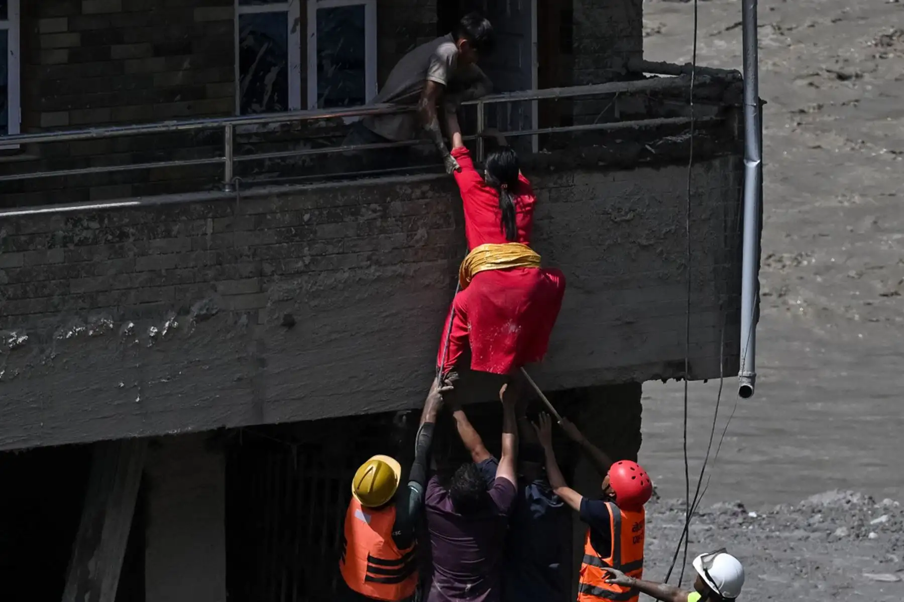 Equipos de rescate auxilian a residentes atrapados en una vivienda sepultada por el lodo tras unas inundaciones repentinas en Trishuli, en el distrito nepalí de Nuwakot. Foto: AFP