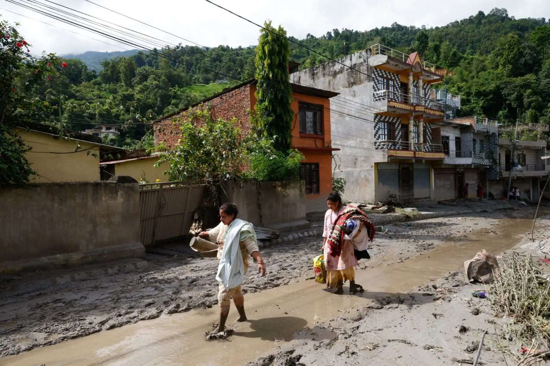 Sobrevivientes de inundaciones regresan a sus hogares tras una crecida repentina en la aldea de Devighat, distrito de Nuwakot, Nepal. Foto: EFE