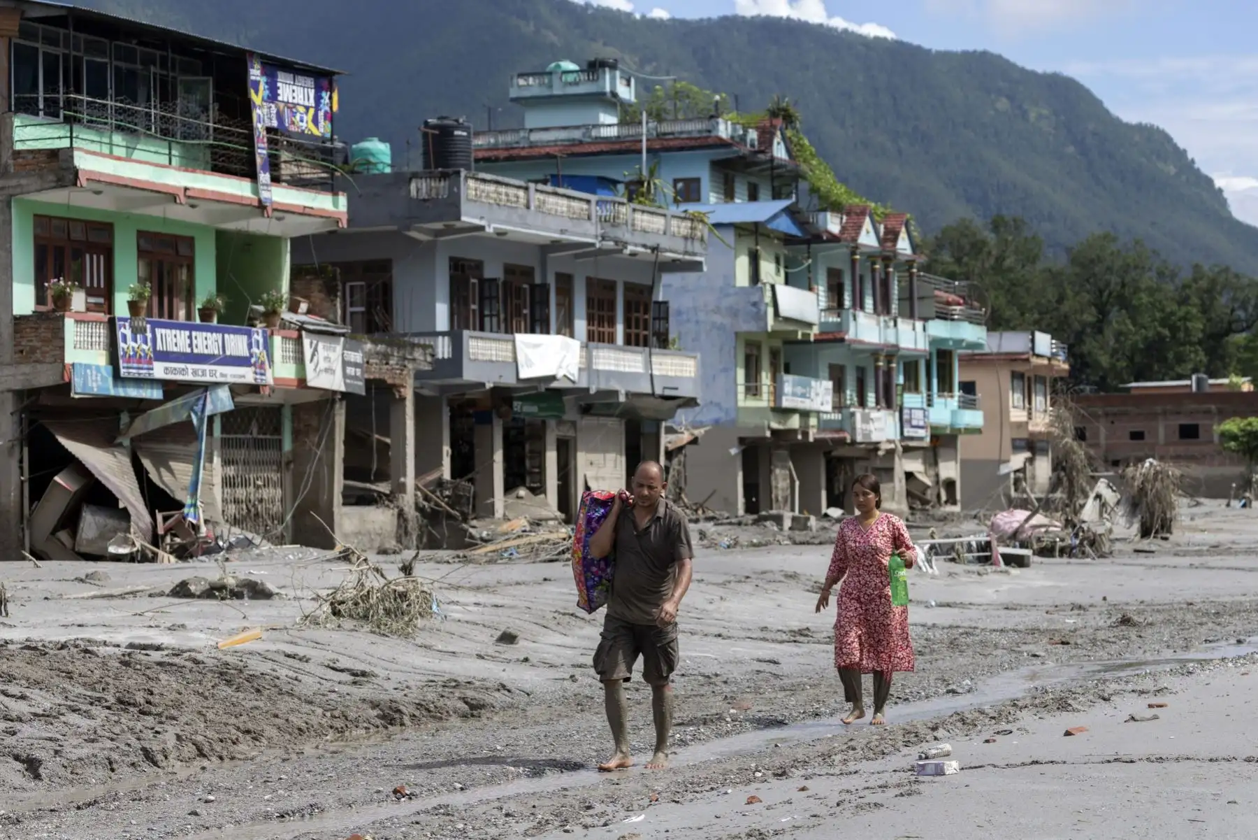 Sobrevivientes de inundaciones regresan a sus hogares tras una crecida repentina en la aldea de Devighat, distrito de Nuwakot, Nepal. Foto: EFE