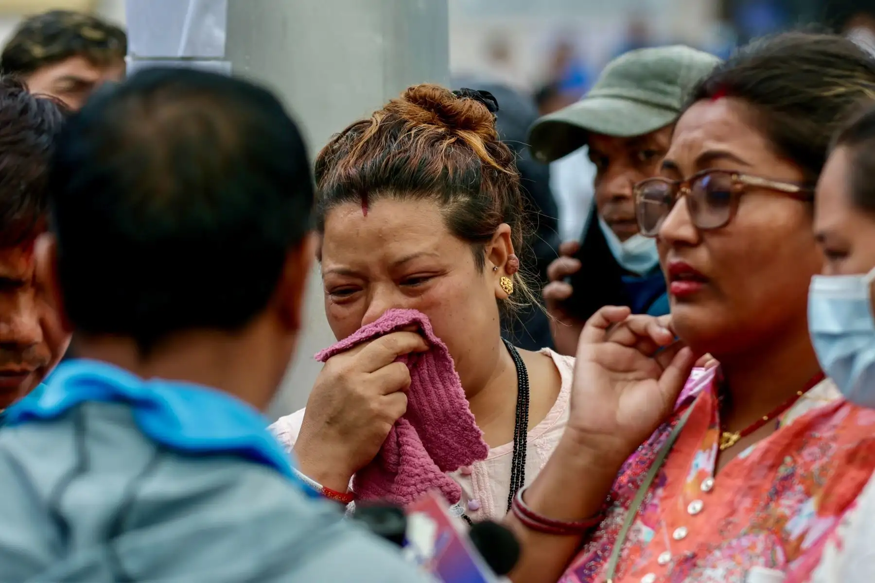 Personas expresan su pesar mientras aguardan noticias sobre sus familiares tras las repentinas inundaciones, en el Hospital Universitario Tribhuvan (TUTH) de Katmandú, Nepal. Foto: EFE