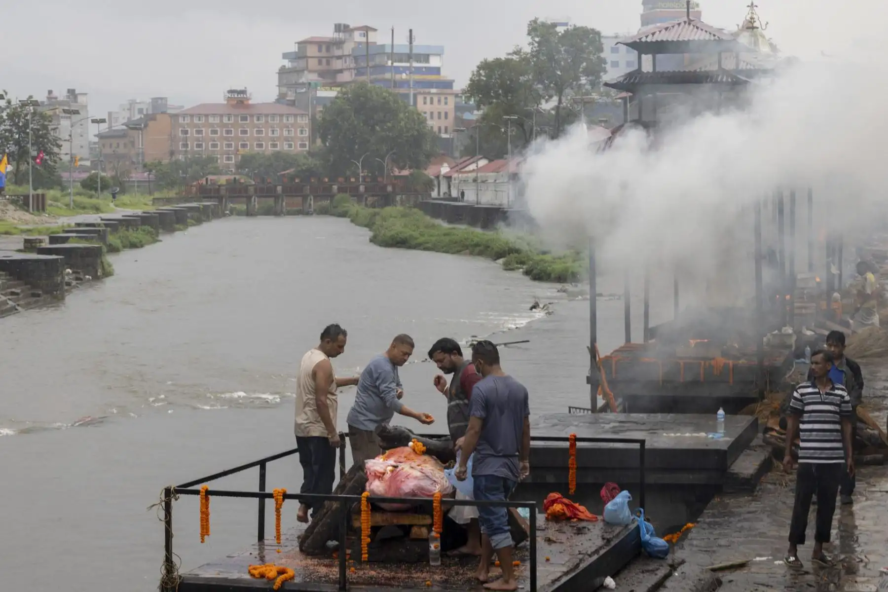 Una fotografía proporcionada por el ejército de Nepal muestra a miembros de la familia rindiendo sus últimos respetos a Rohan Shrestha, una de las víctimas de las inundaciones repentinas de Rasuwa, en el centro de cremación de Pashupati en Katmandú, Nepal. Foto: EFE