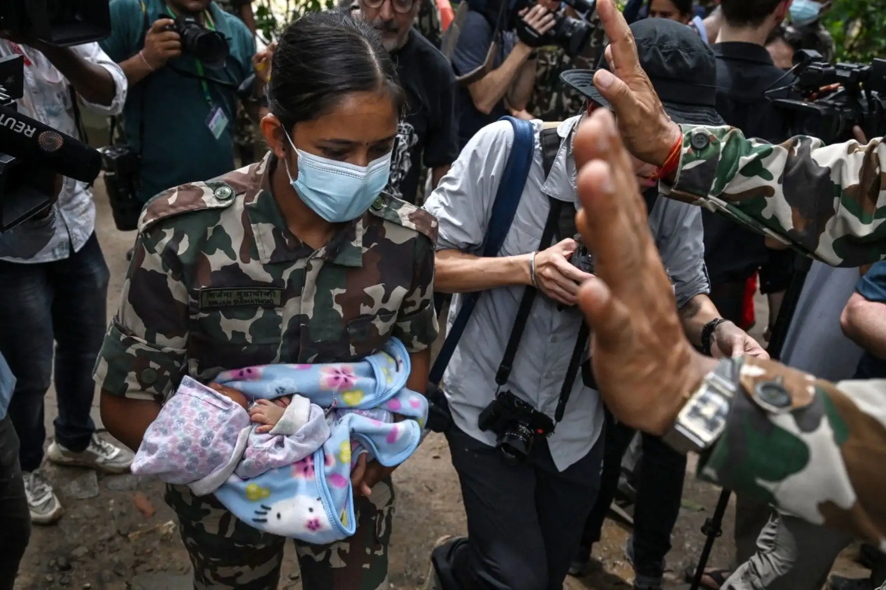 Un miembro del ejército lleva a un bebé rescatado tras las inundaciones repentinas en el campamento de Trishuli, en el distrito nepalí de Nuwakot. Foto: AFP