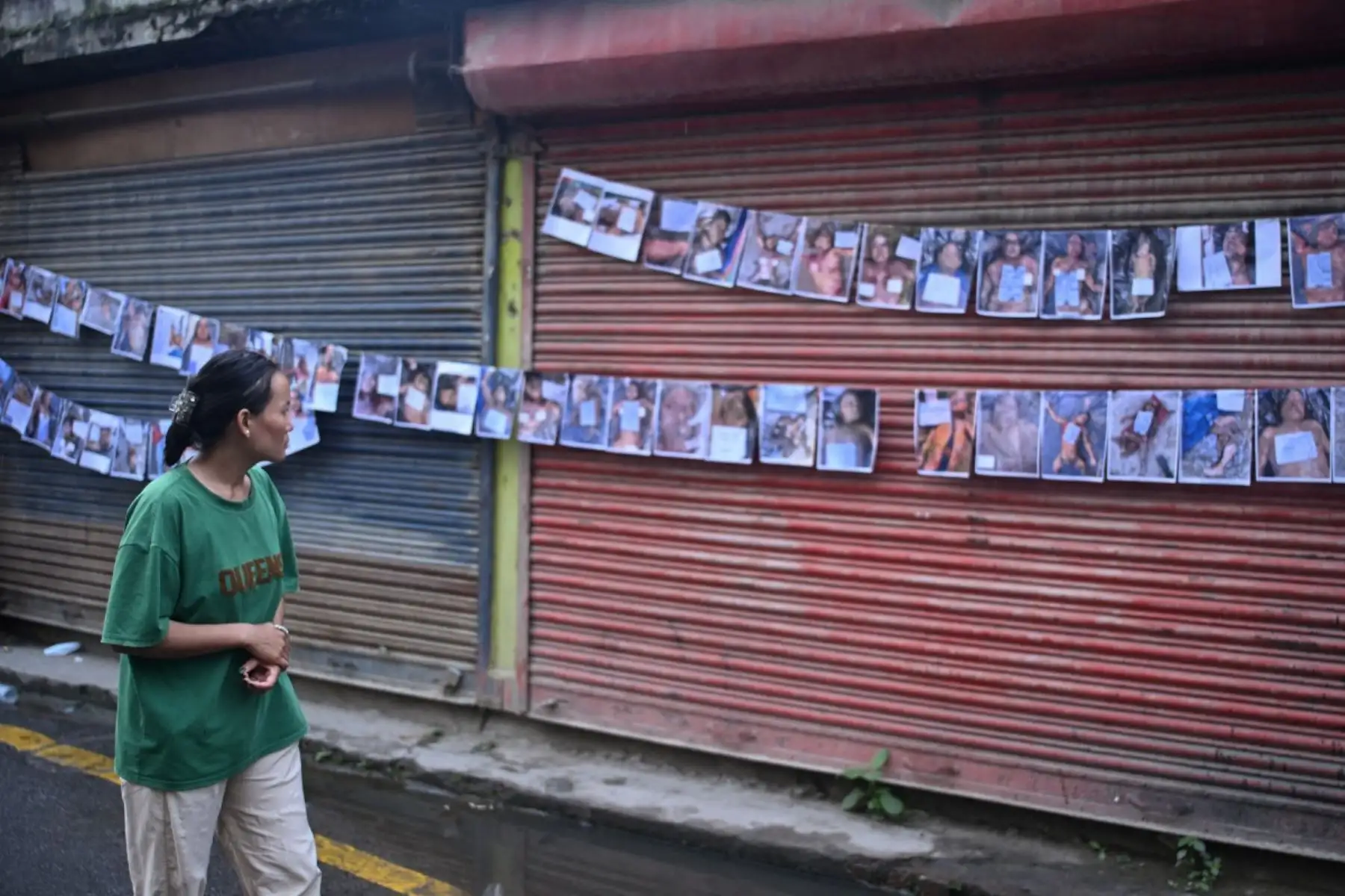 Una mujer observa fotografías de personas desaparecidas y fallecidas tras las inundaciones repentinas en Nepal, frente a un hospital de Katmandú. Foto: AFP